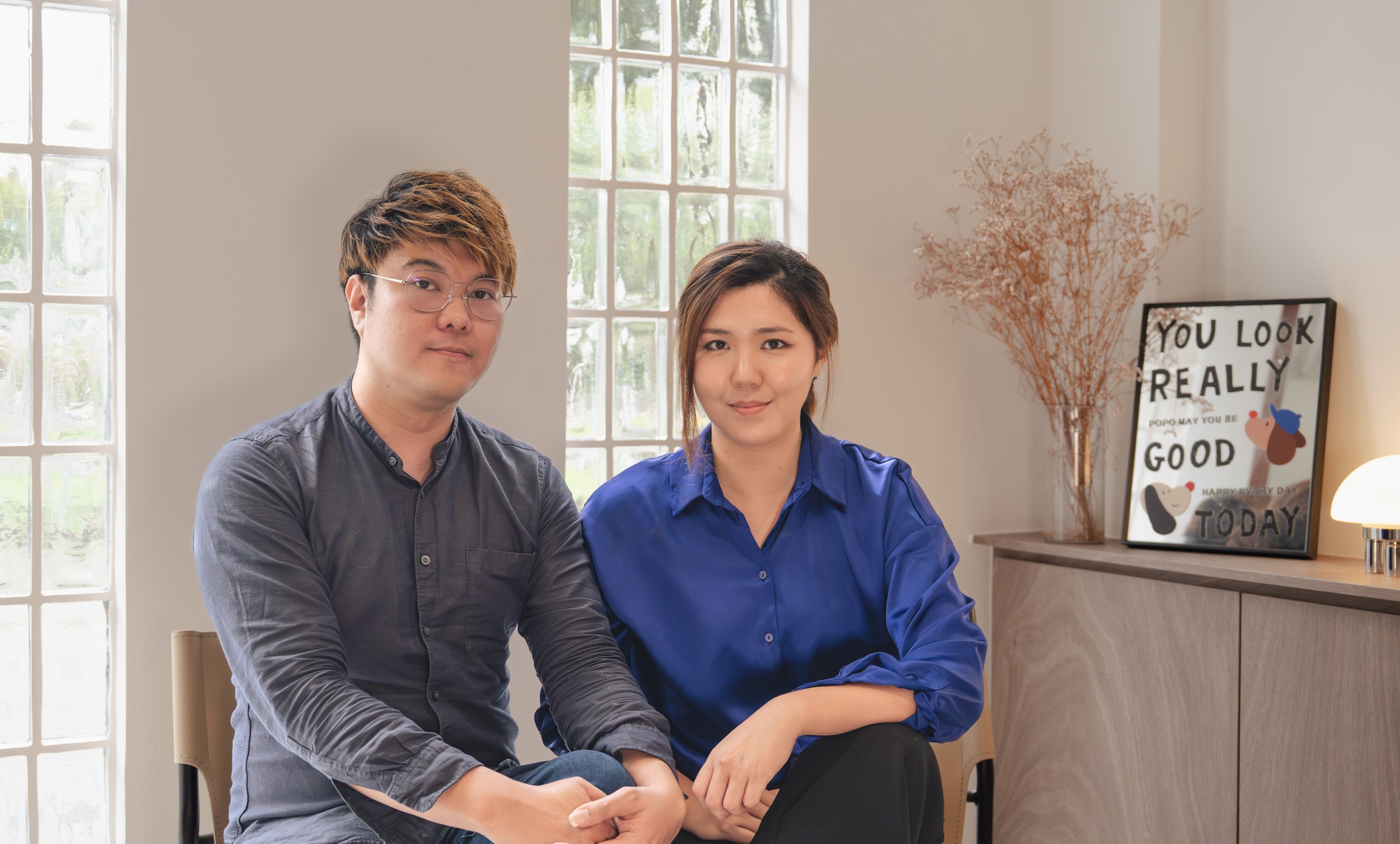 Founders of Couple Abode. Chally and Alson sitting at Studio Couple Abode, they are both professional certified interior designer in Singapore.