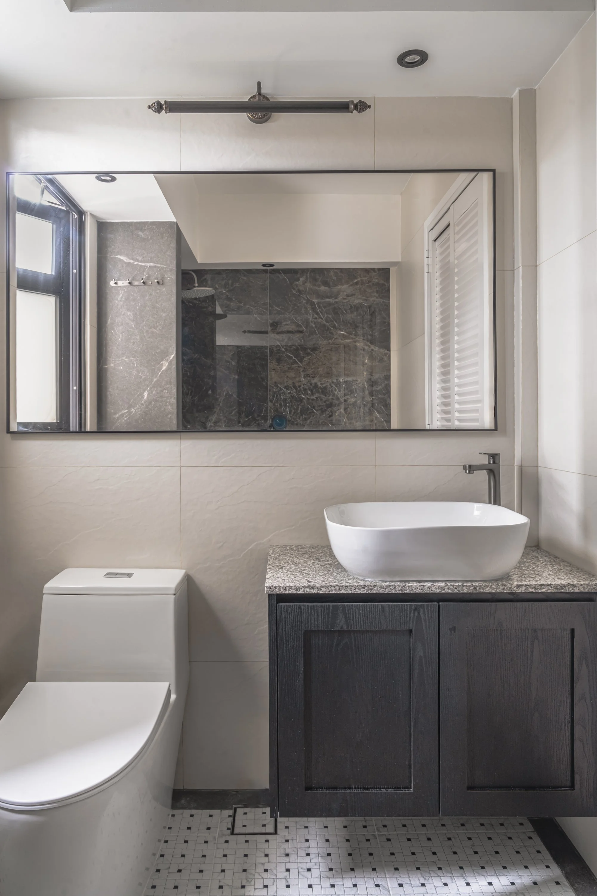 Elegant bathroom with grey marble shower wall, large mirror, vessel sink, and dark wood vanity
