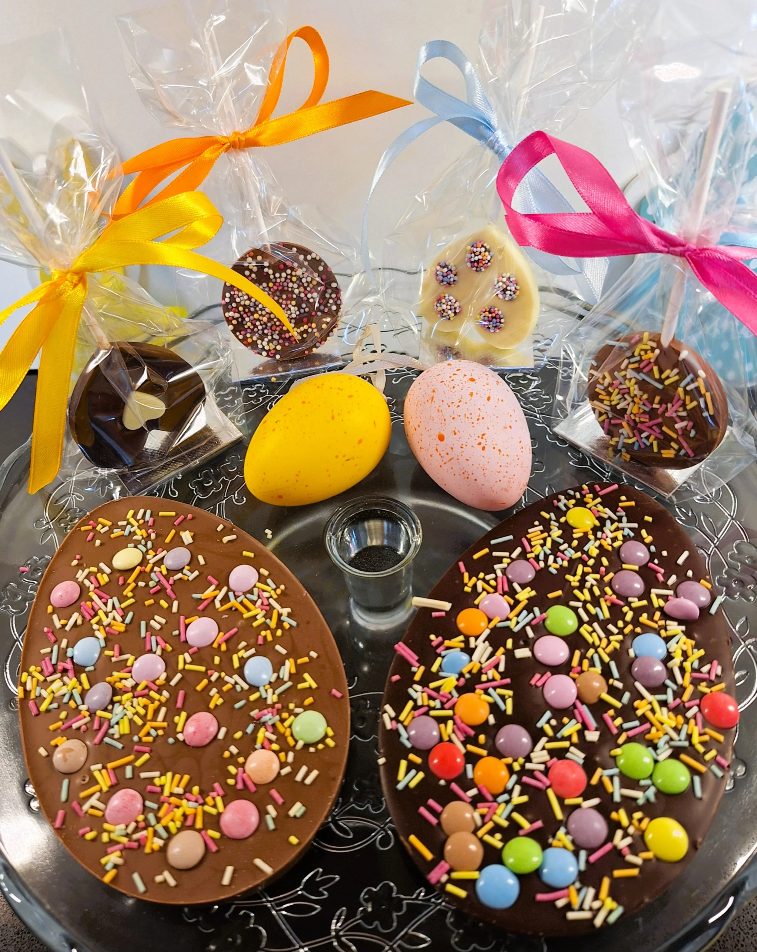 Easter chocolate gift selection with handmade eggs and lollipops wrapped with colourful ribbons and sprinkles