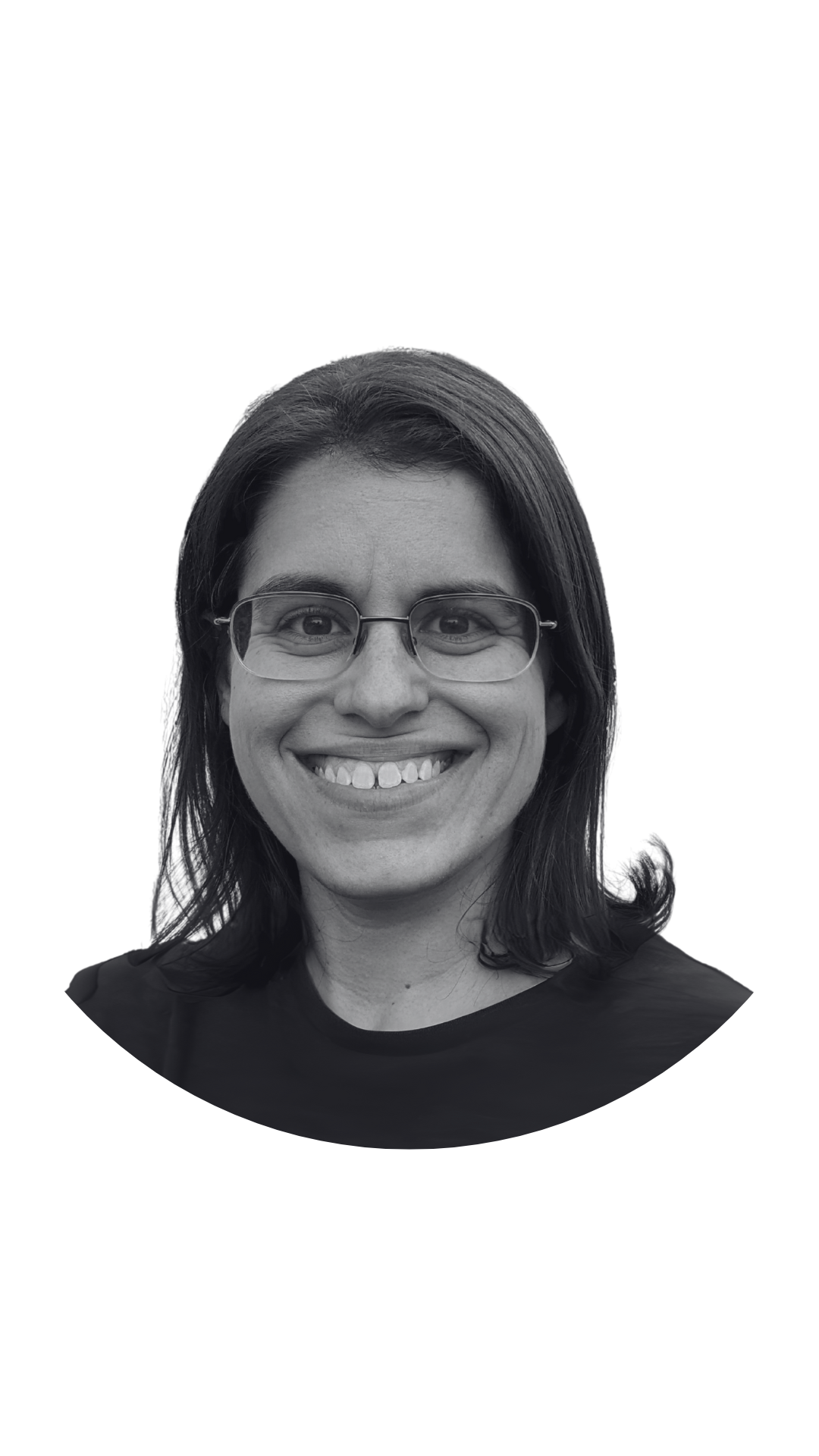 Black and white photo of a woman with glasses, smiling, with shoulder-length dark hair, wearing a dark shirt.
