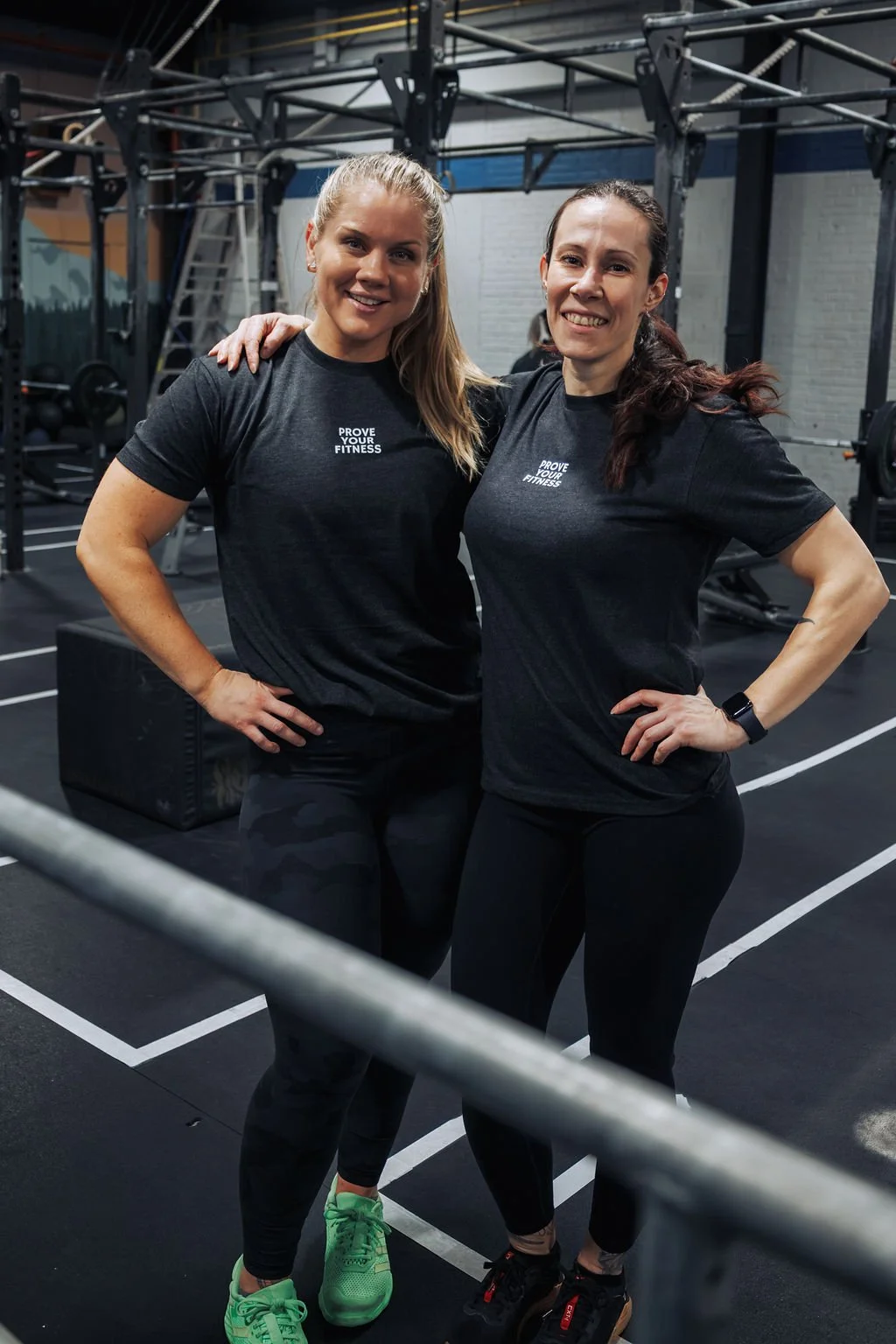 Two women in black workout shirts with 