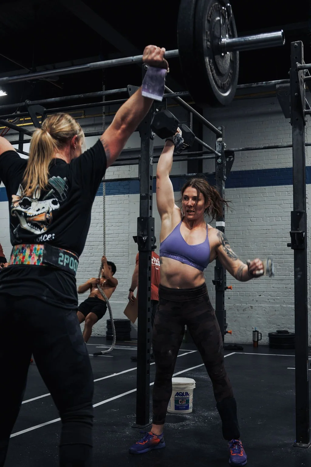 Women lifting weights at a gym during a workout session.