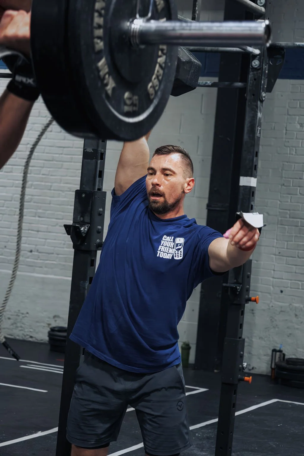 A man lifting a heavy barbell in a gym.