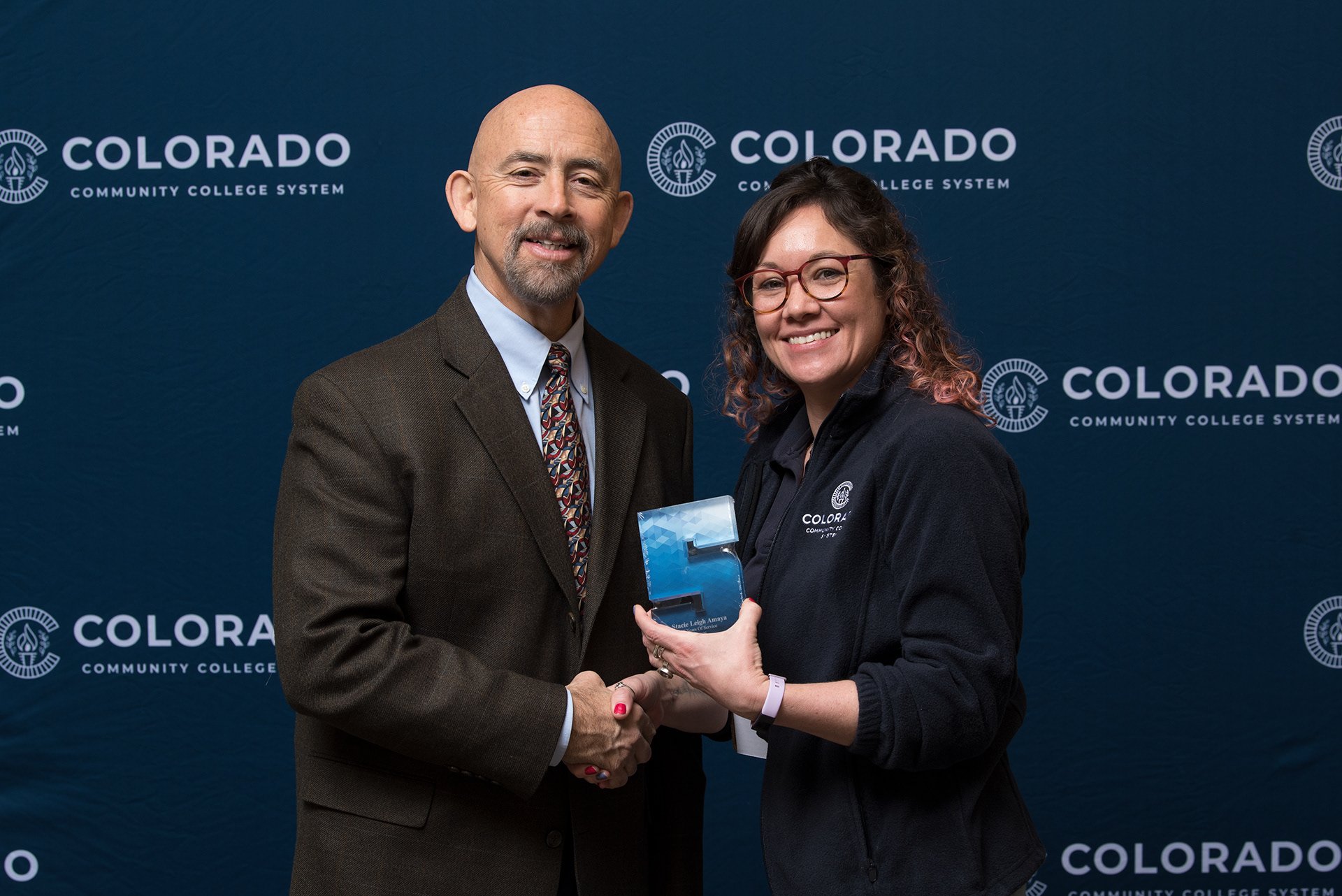 A event photograph with Joe Garcia (the Chancellor of the Colorado Community College System (CCCS)) and a guest at at Step and Repeat Photobooth at Red Rocks Community College in Denver, Colorado. Photo by Amanda Deutsch of Just My Luck Photography.