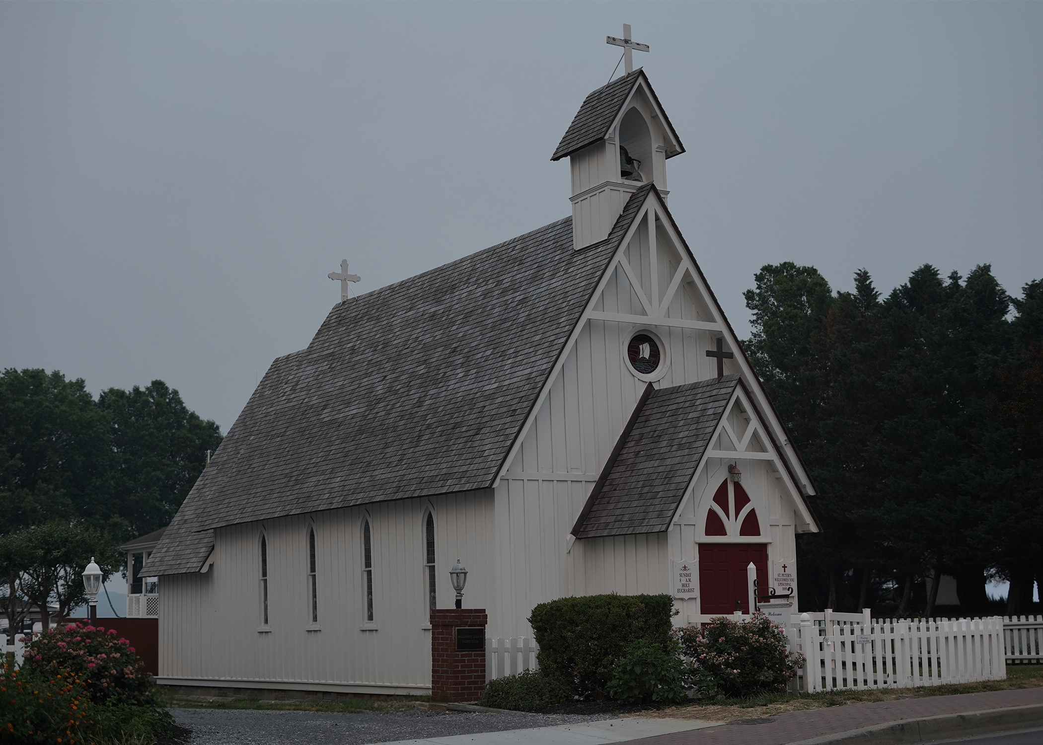 Foggy scene with old white wooden church.