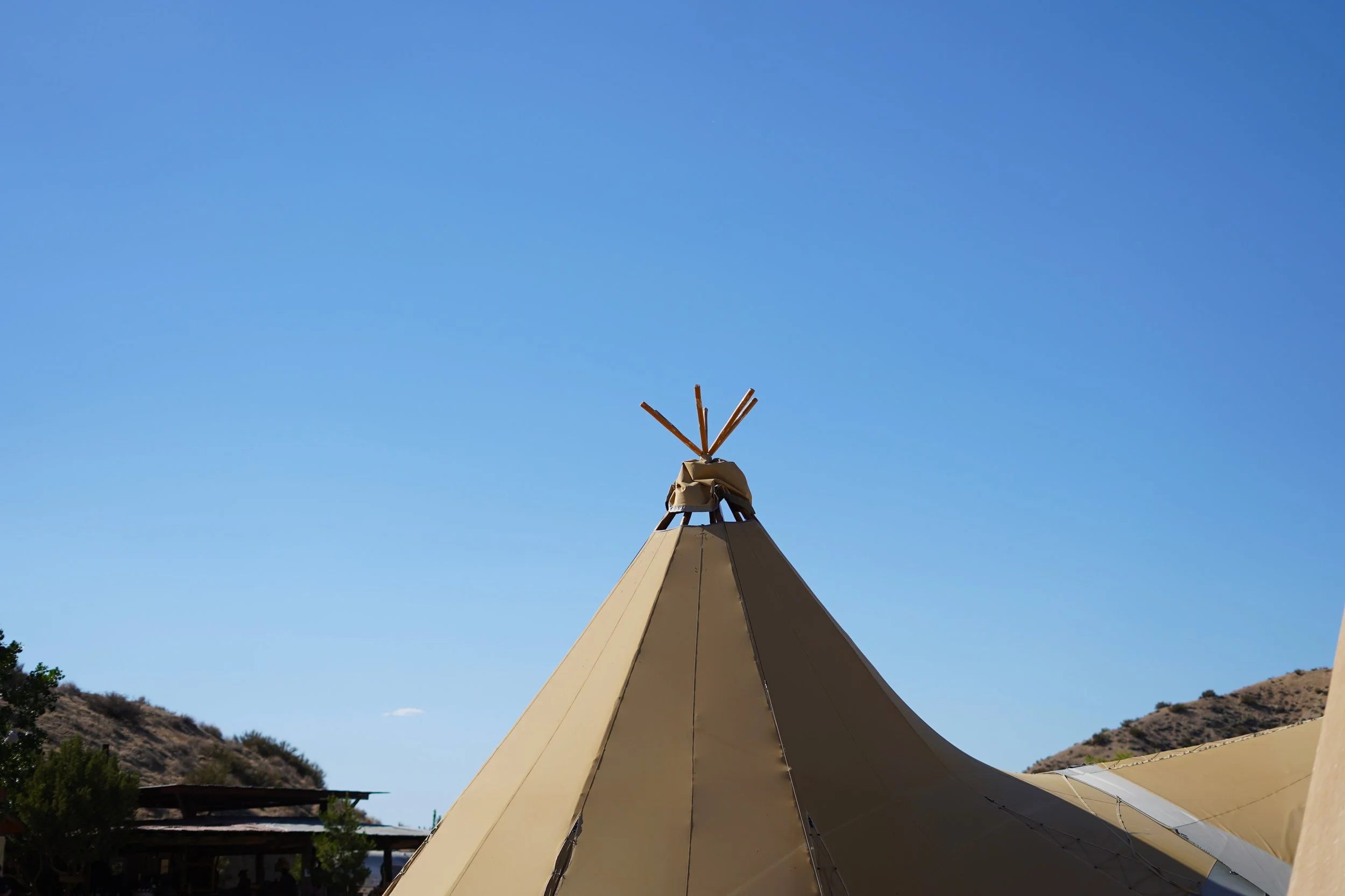 Top of tent against bright blue sky.