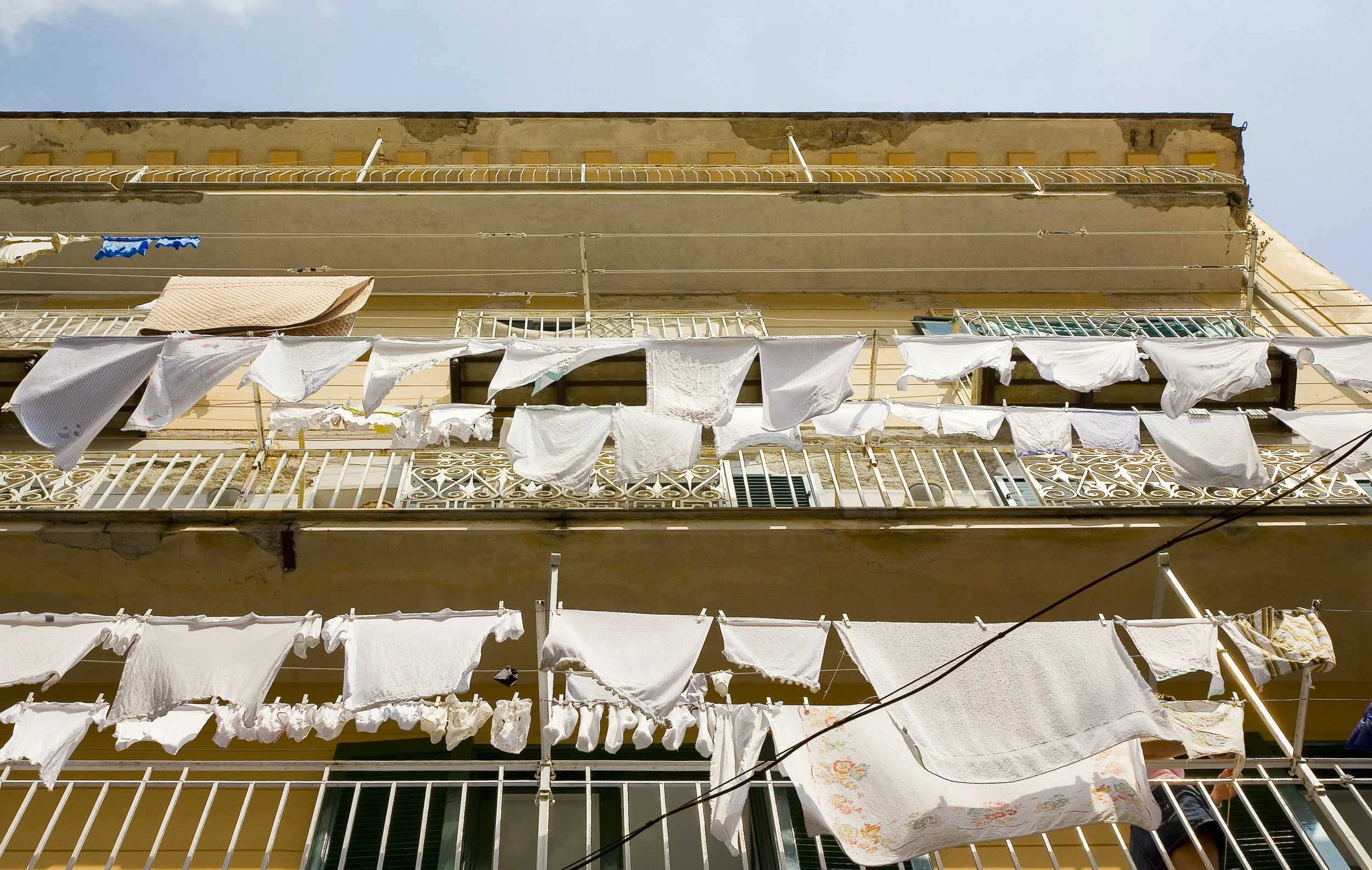 Balcony of an apartment building with laundry hanging on clotheslines.