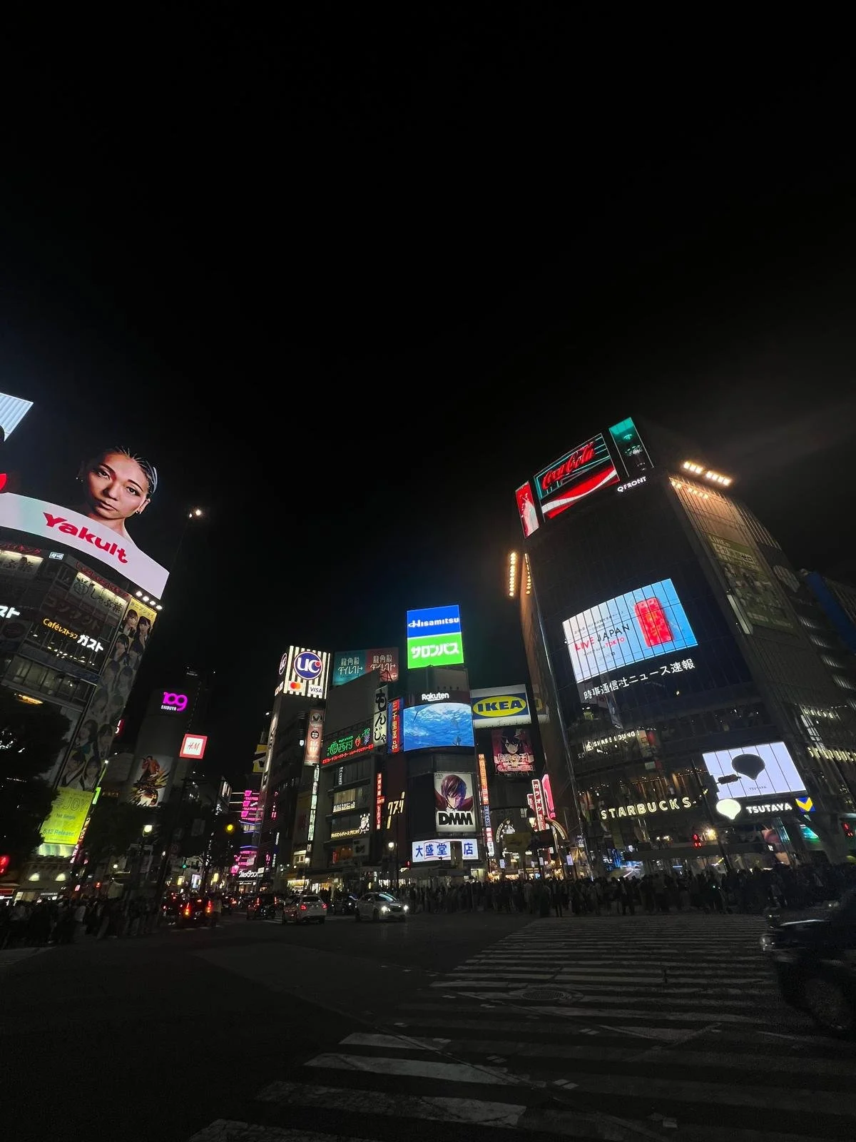 Shibuya crossing Tokyo, Japan at night, bustling city lights and buildings