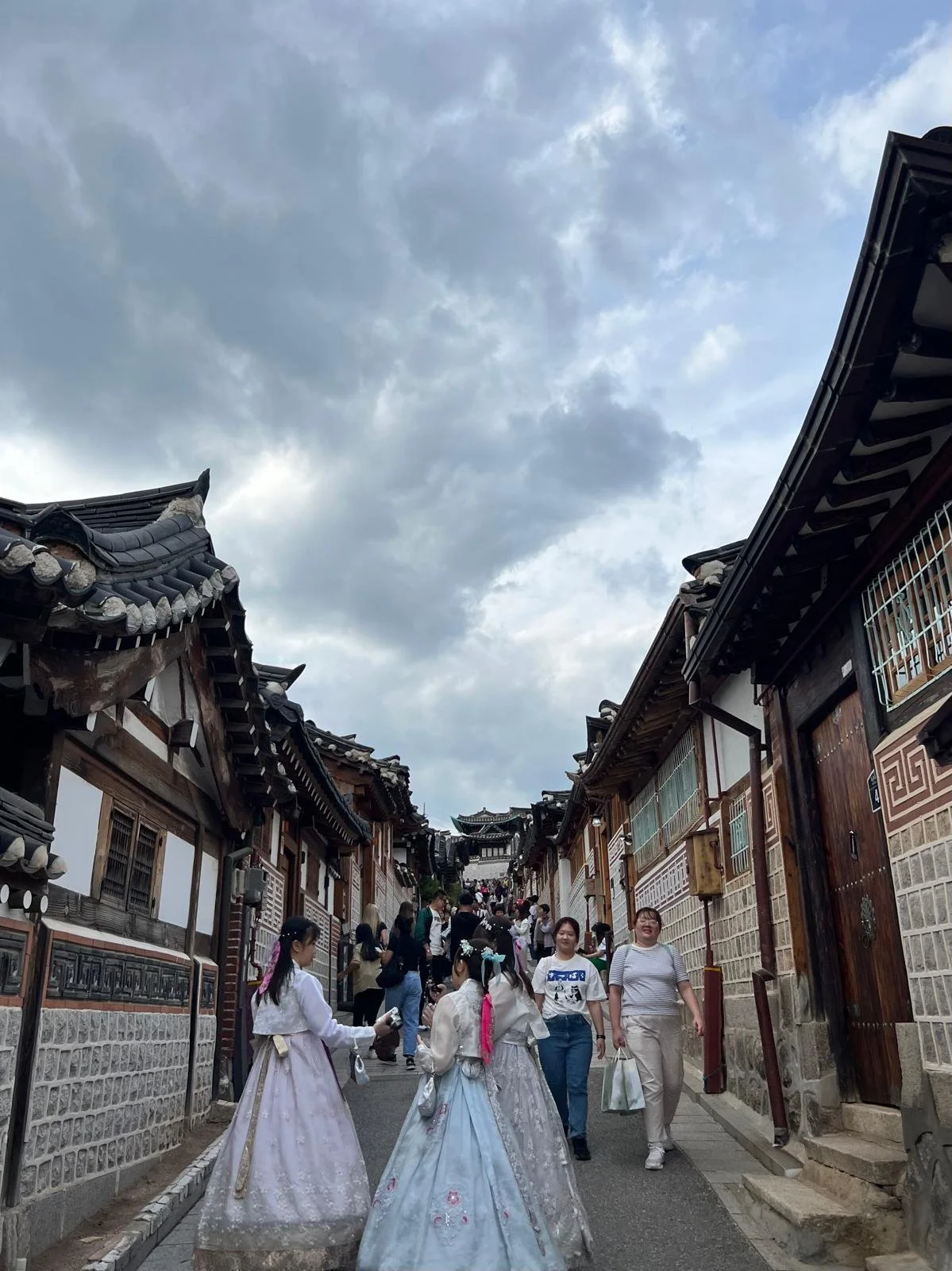 the bustling, traditional and authentic bukchon hanok village, seoul, South Korea featuring traditional Korean dresses and old fashioned houses