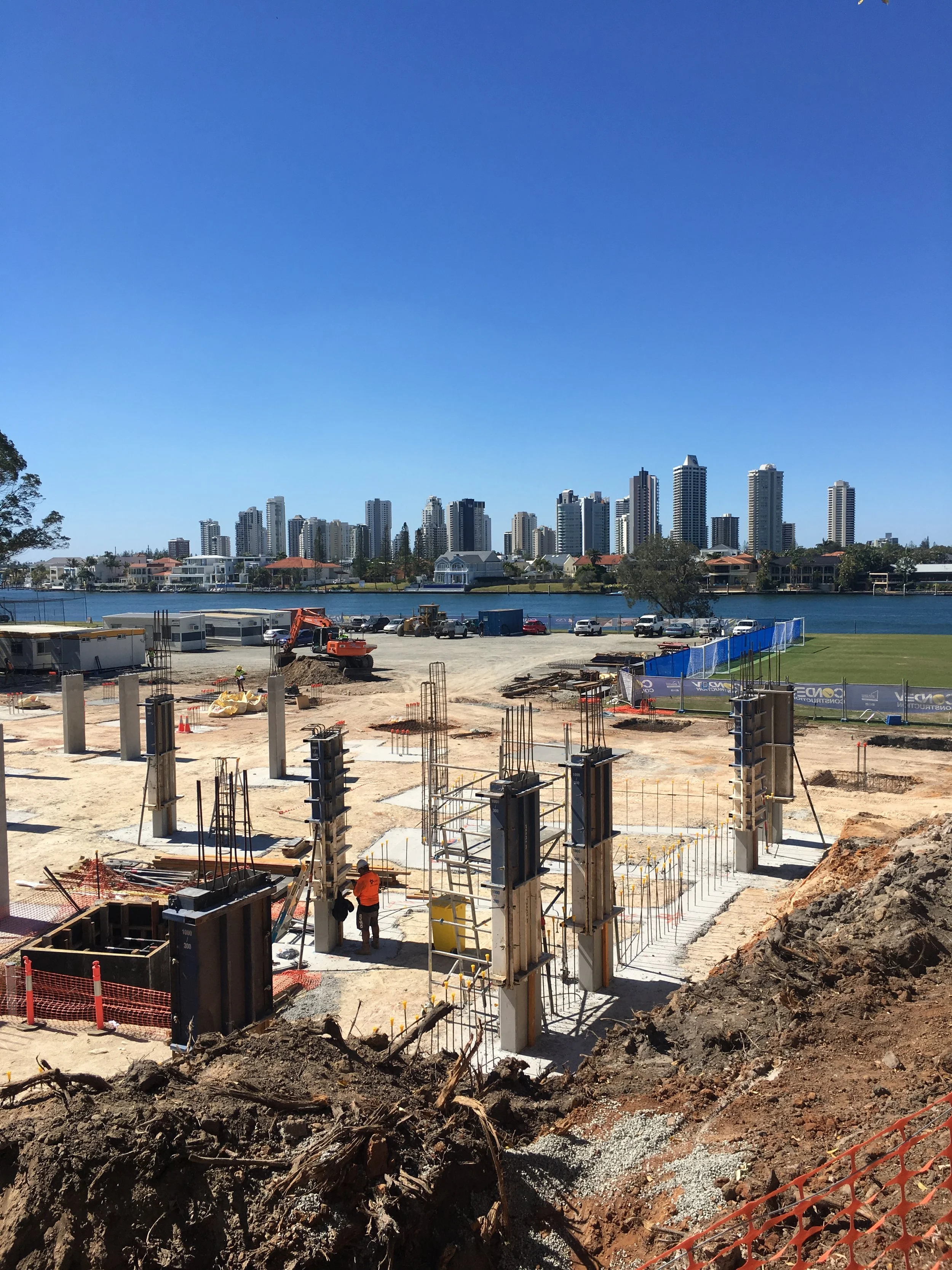 Construction site with columns in progress, city skyline in background
