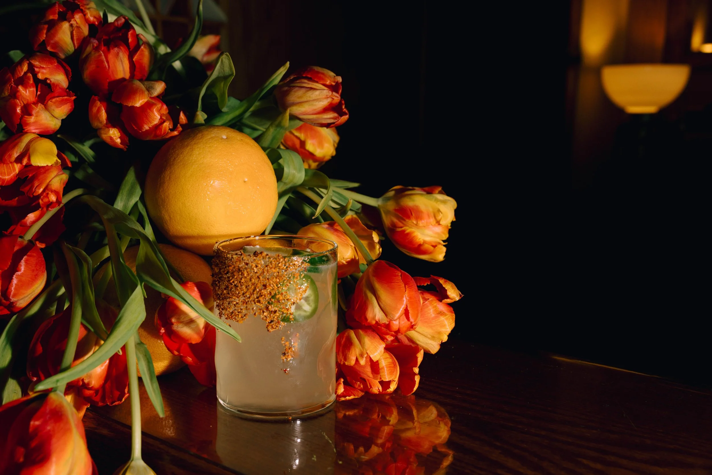 Editorial-style detail photo of a wedding cocktail with orange tulips, photographed by Kirstin K Photo.
