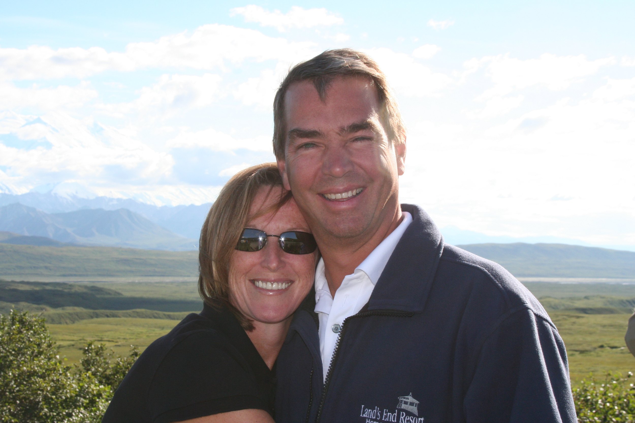 Kirstin’s parents smiling together on a scenic overlook during a trip.
