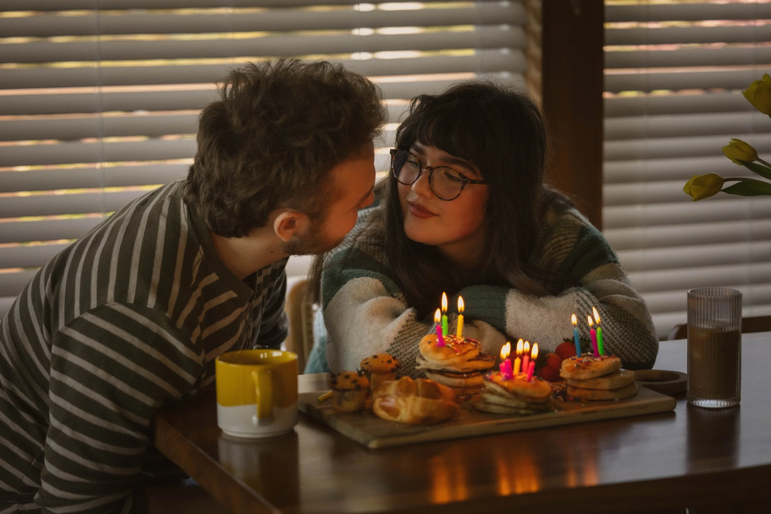 Intimate at-home couples session with cupcakes and candles during a cozy documentary-style photoshoot.