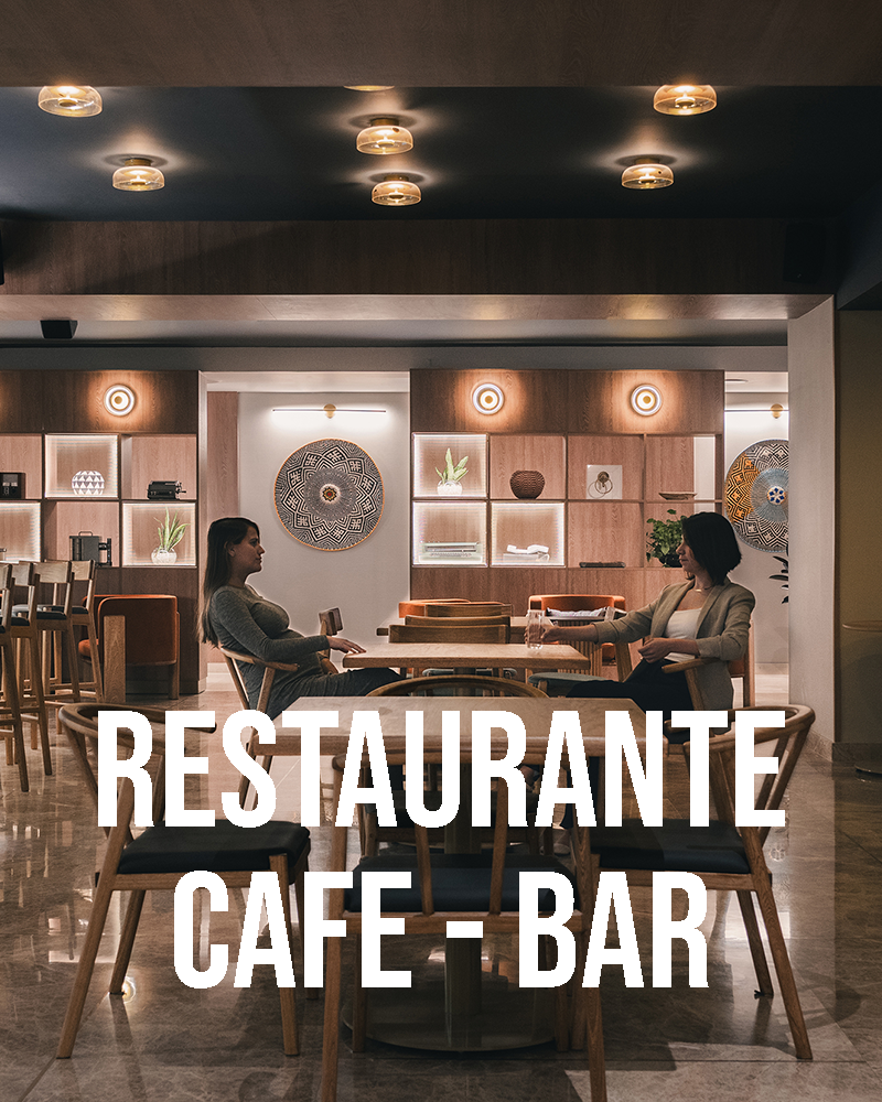 Fotografía de diseño de interiores para un restaurante. Espacio con luz ambiente y dos personas compartiendo en el espacio
