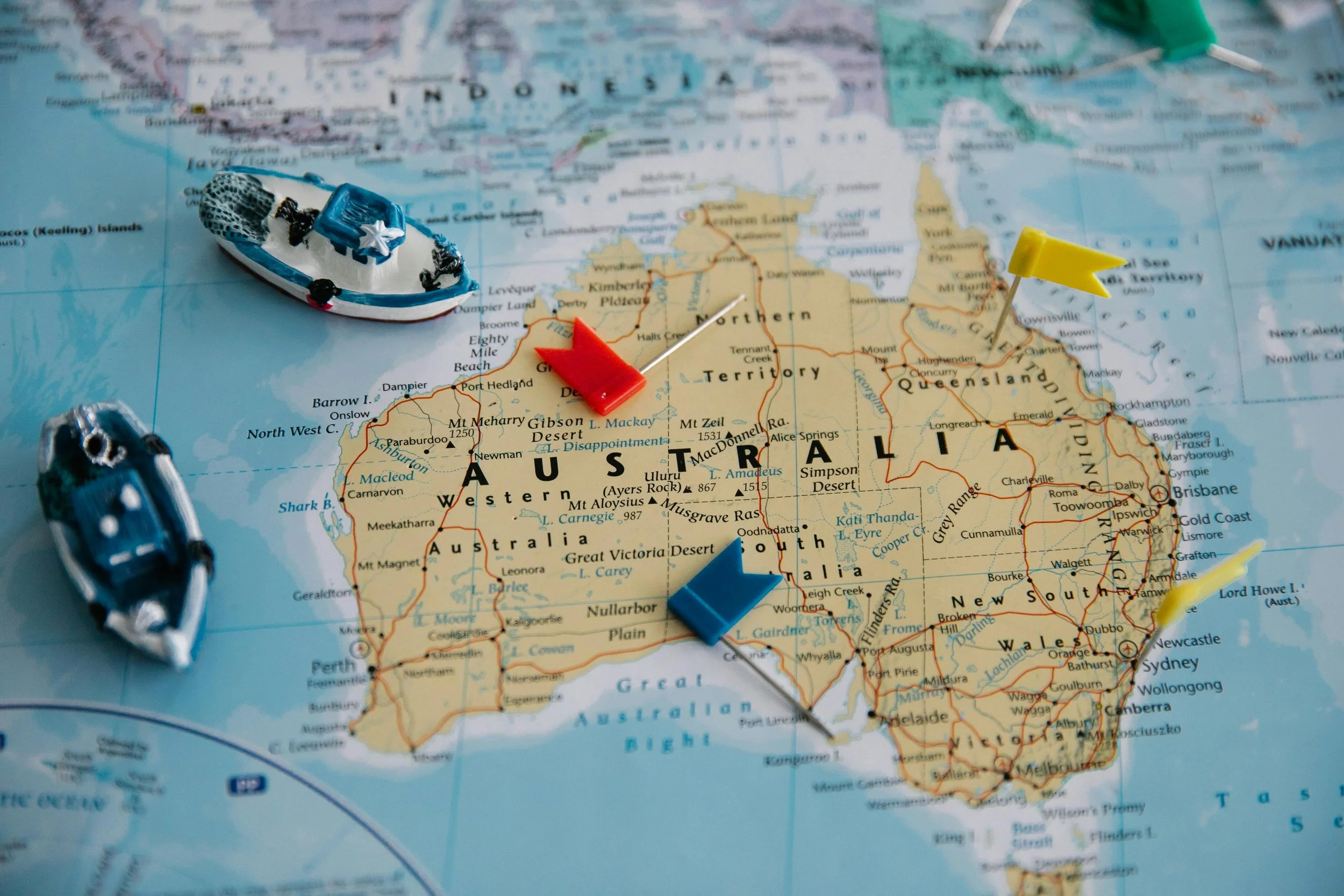 Map of Australia with miniature boats and colored pins marking locations.