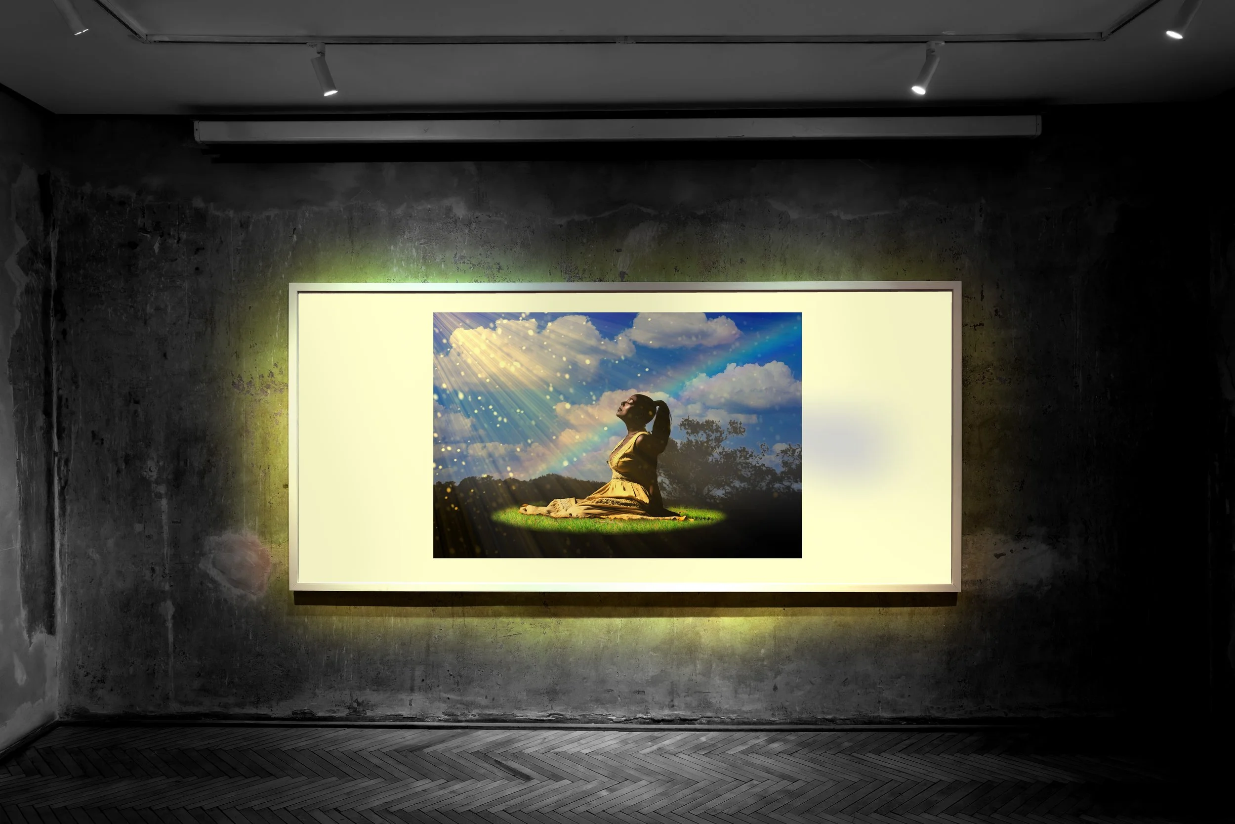 A woman sitting cross-legged on a grass field, looking up at the sky with rays of sunlight and a rainbow.