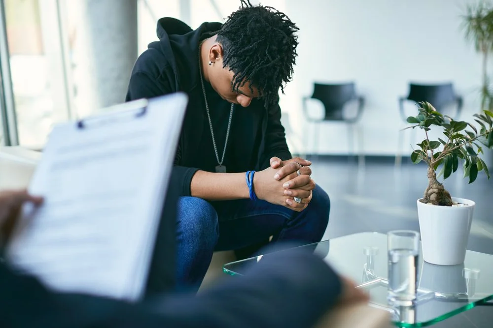 young man looking down during autism assessment