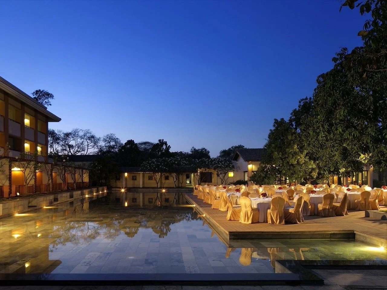 Reflecting pool and dinner setup at dusk at Radisson Blu Alibaug