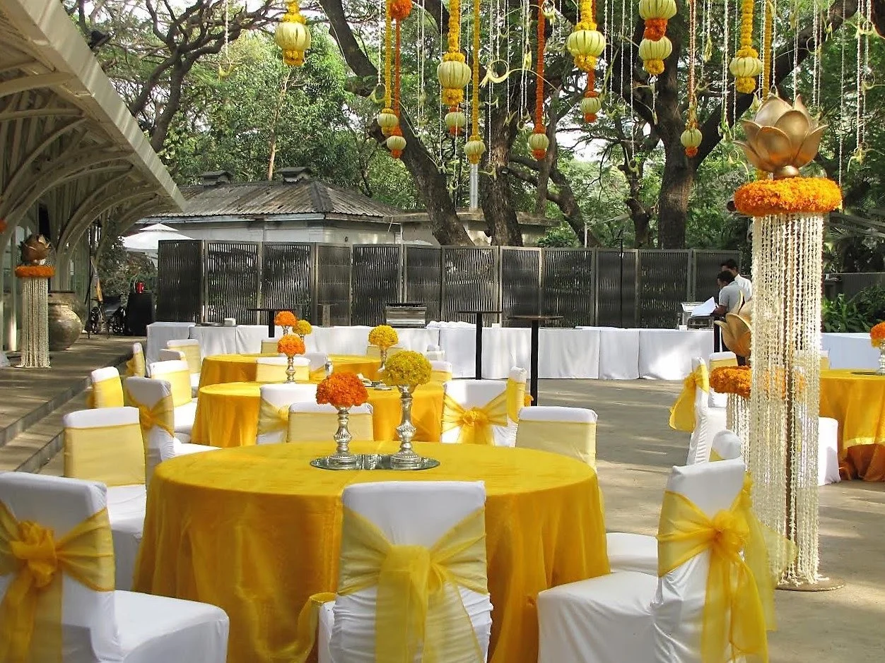 Yellow mehendi table setup with hanging decor at Tote on the Turf