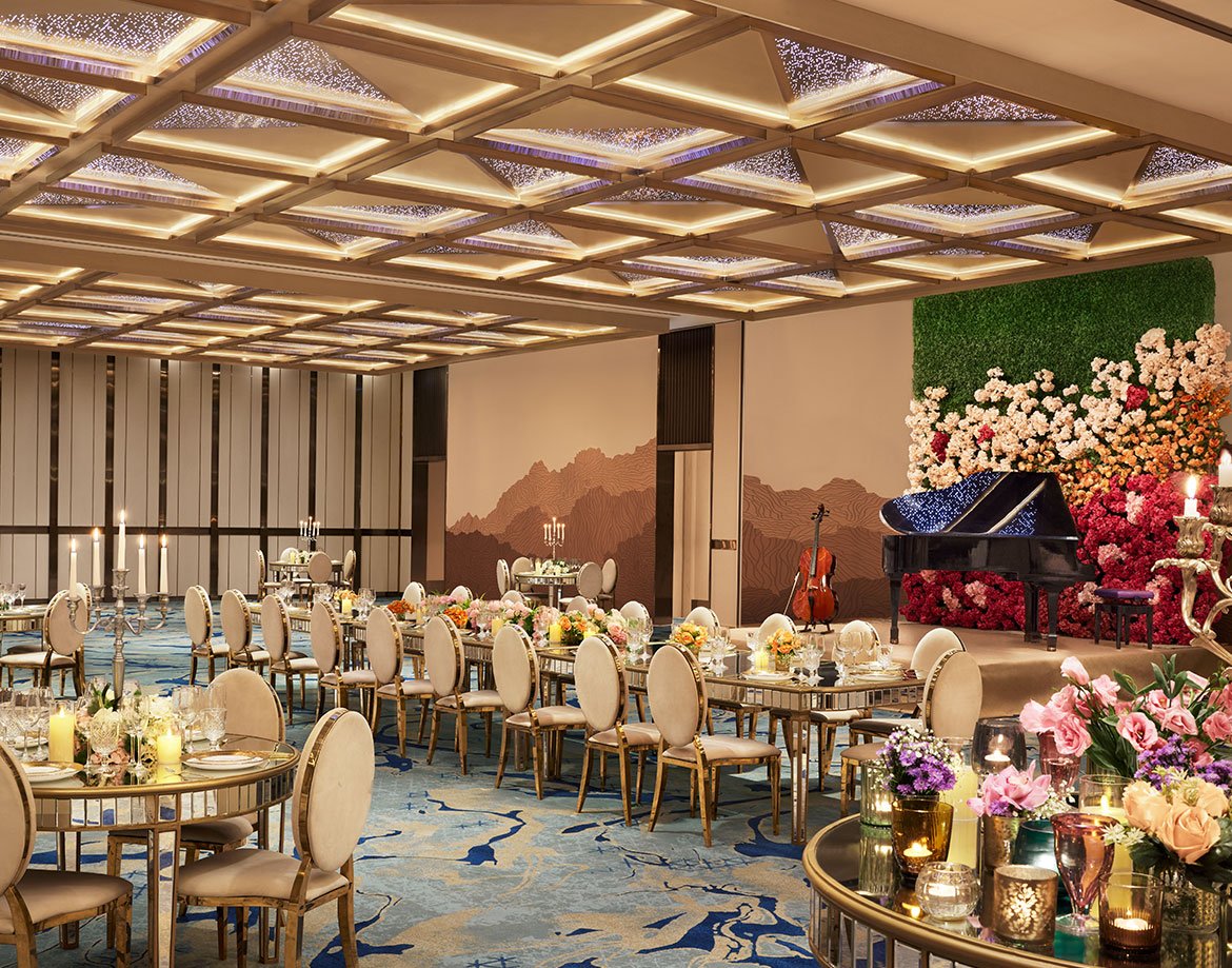 Ballroom with long dinner tables and florals at JW Marriott Juhu