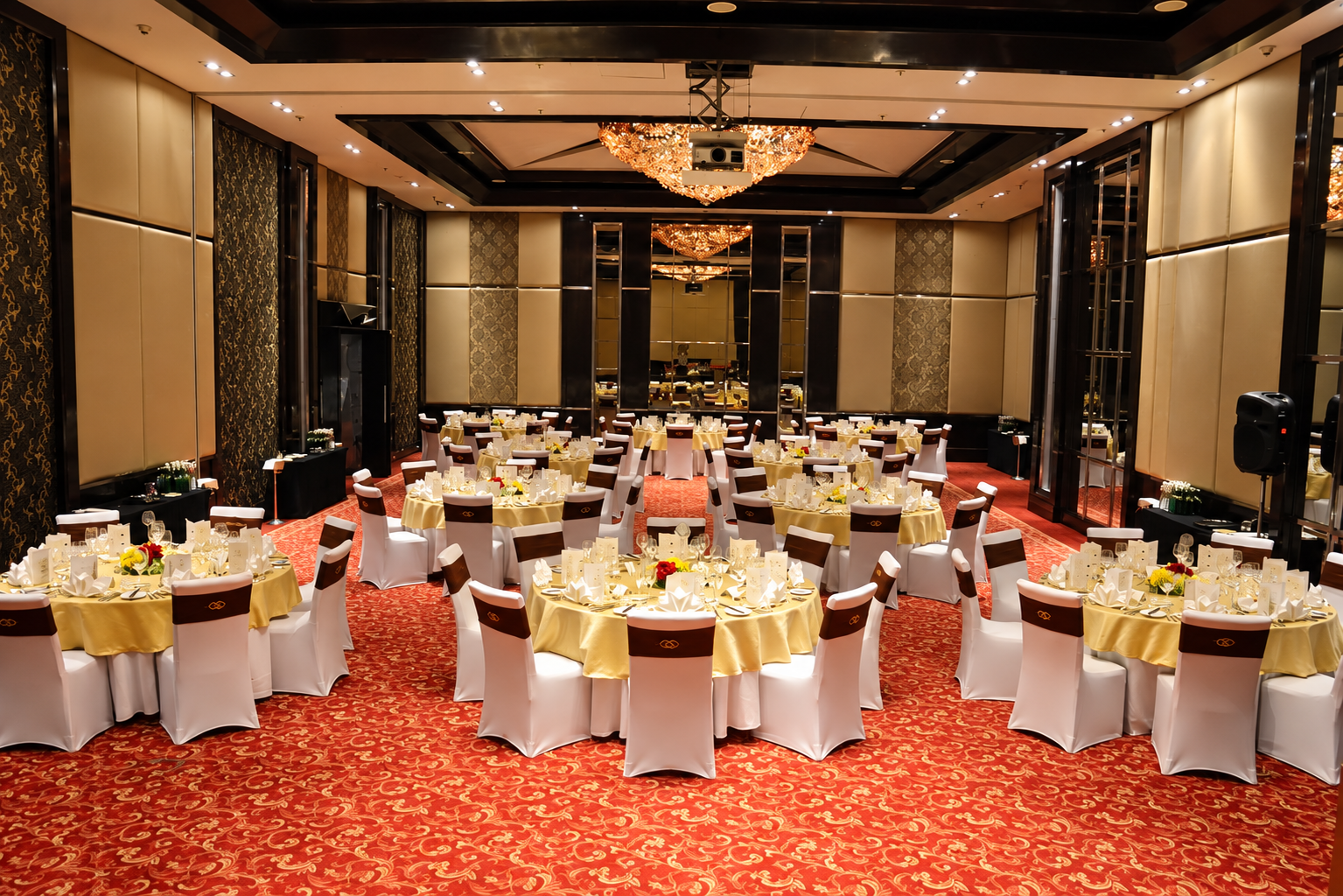 Banquet hall with yellow sashes on red carpet at Sofitel Mumbai BKC