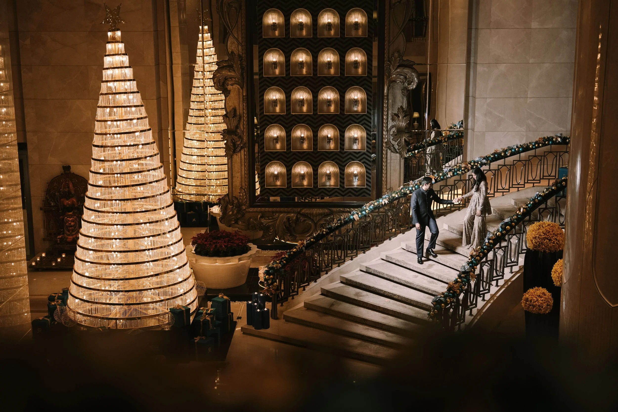 Grand staircase with tall lit tree decor at The St. Regis Mumbai