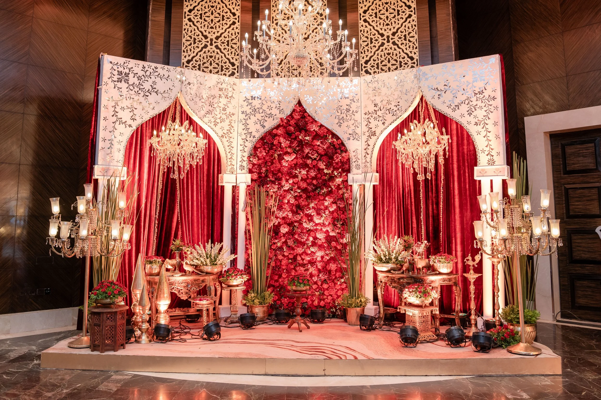 Red floral jharokha stage with candelabras at The St. Regis Mumbai