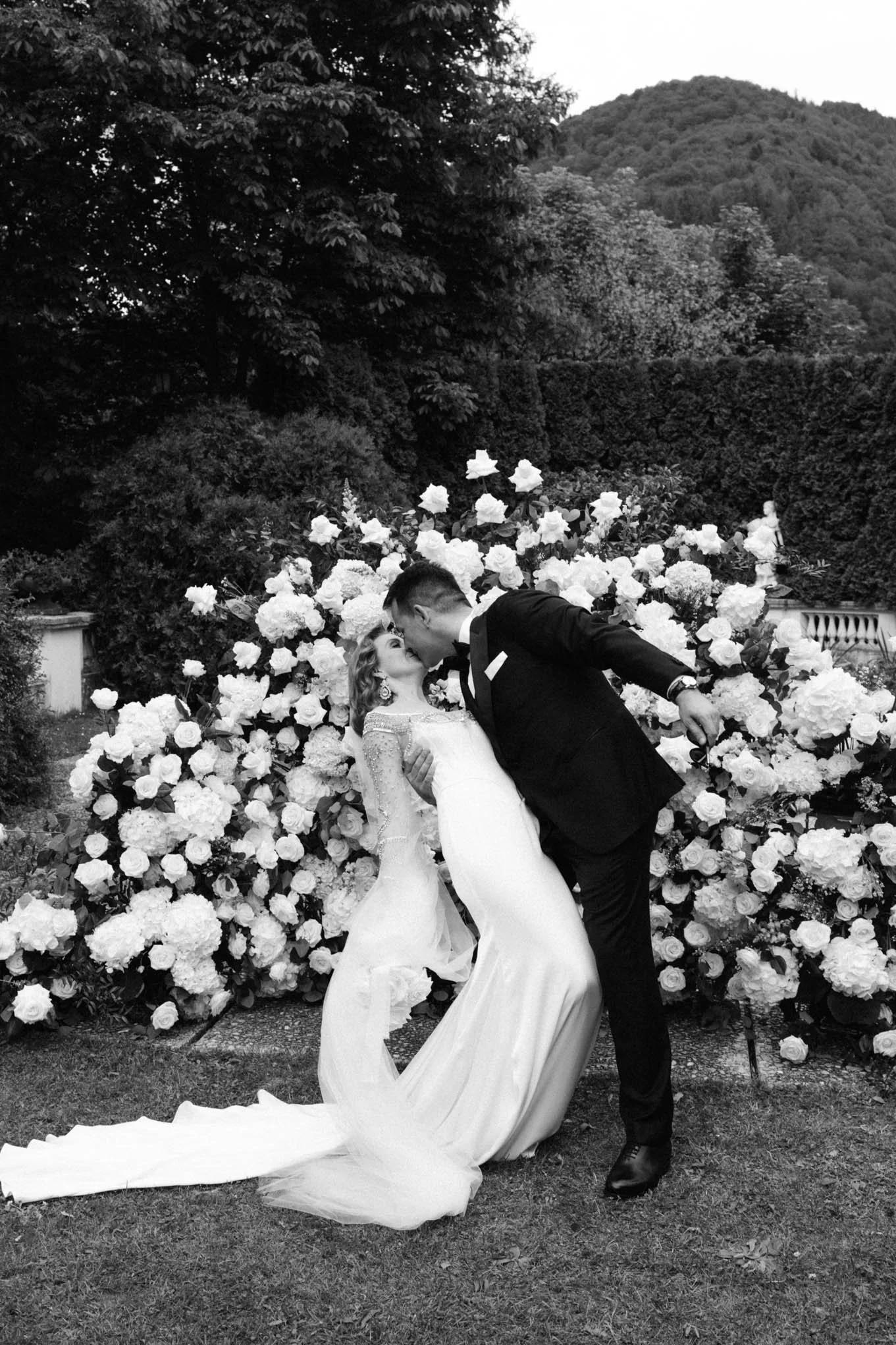Kissing at a wedding with Tuscany style background wedding garden.