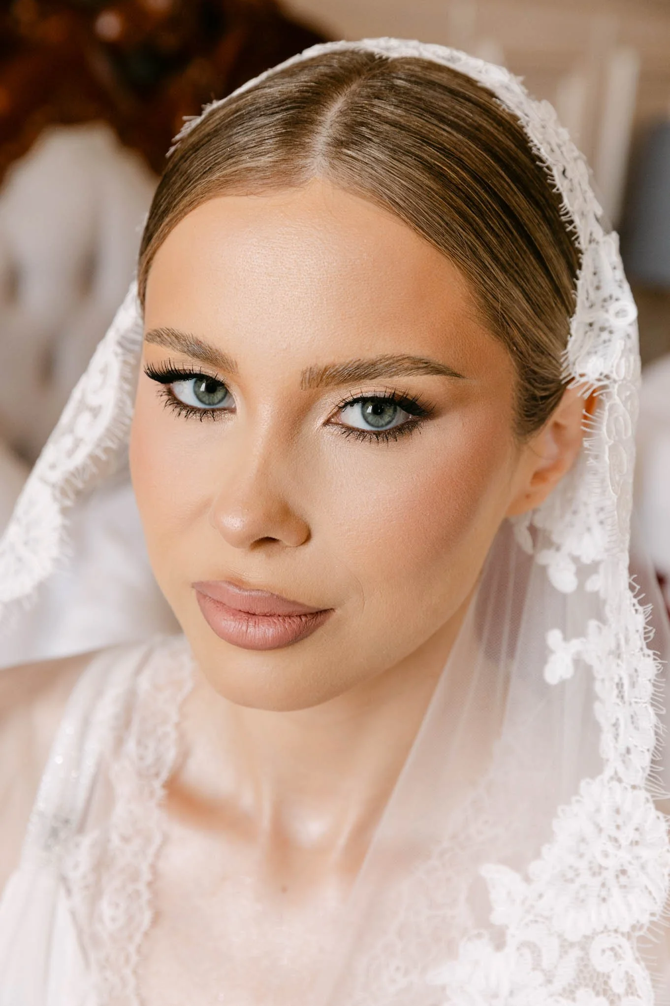 Close-up portrait of a bride with blue eyes, makeup, and a lace veil.Vogue bride!