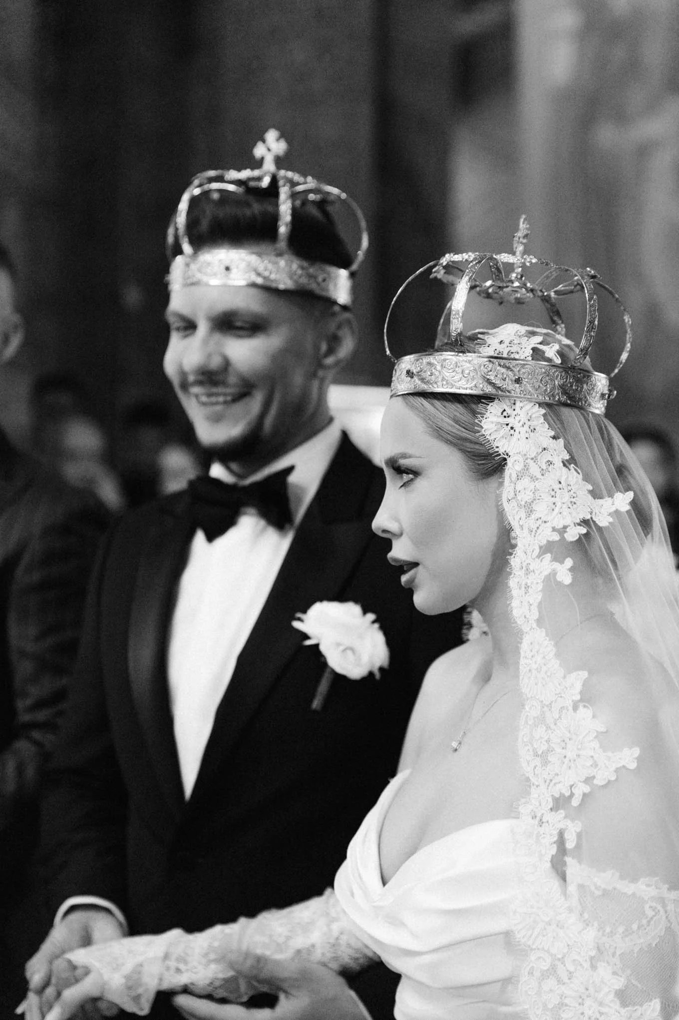 Black and white photo of a bride and groom wearing crowns during a wedding ceremony, holding hands.  French style wedding, as seen in south of france!