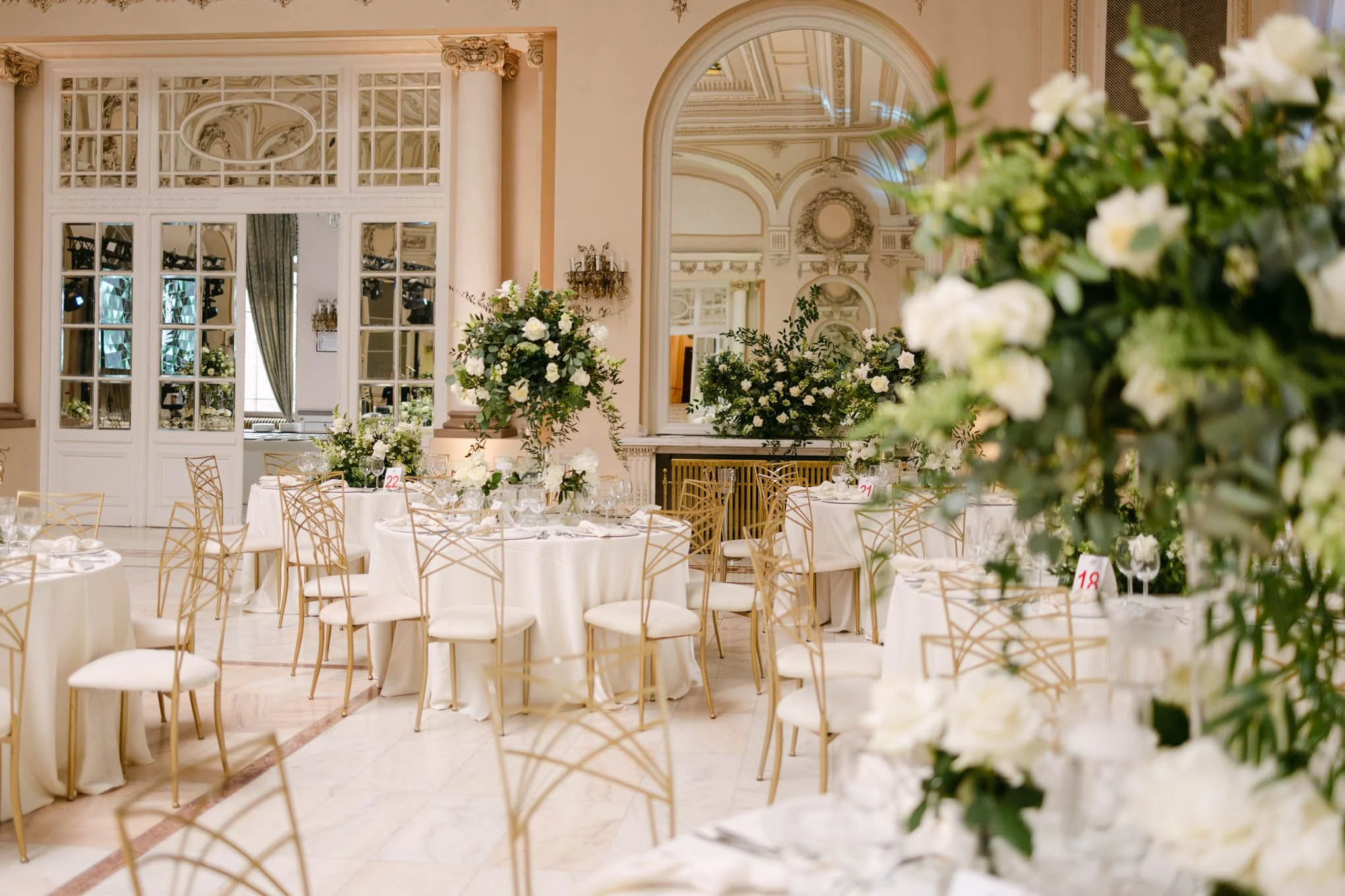 Elegant banquet hall decorated with white flowers and gold chairs for a formal eventn italian wedding style!