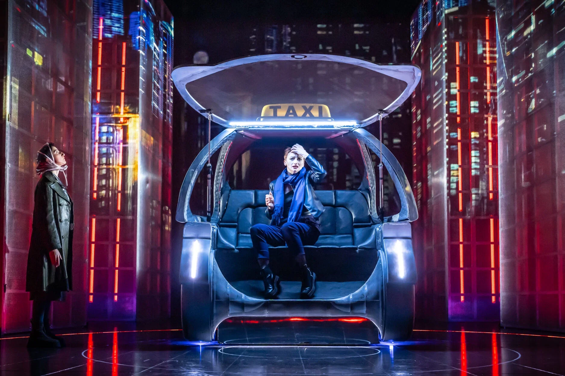 A woman sitting inside a futuristic, transparent taxi with illuminated edges, holding her forehead in distress, and a person standing nearby in a cityscape at night with illuminated skyscrapers.