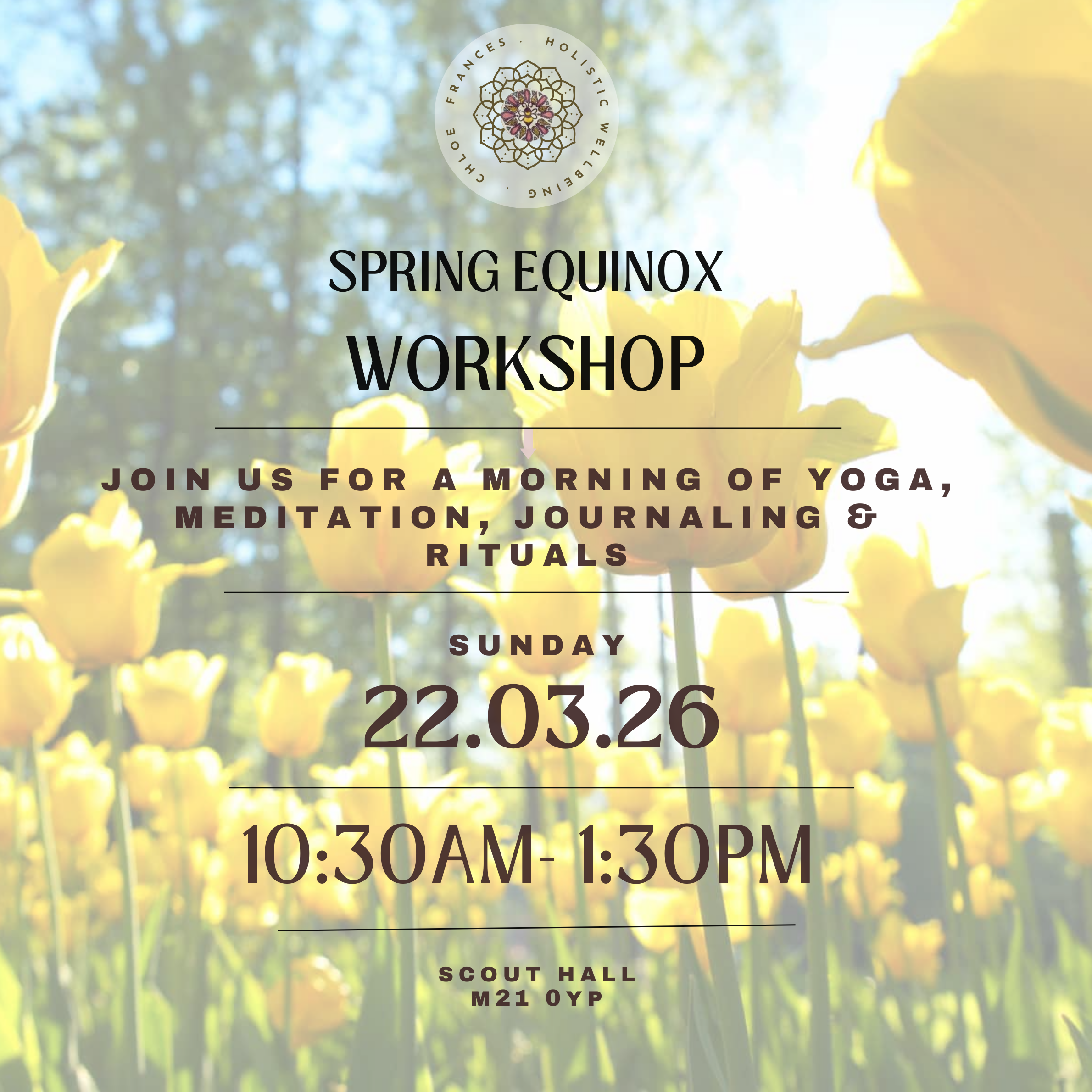 A group of people participating in a yoga or meditation class in a spacious, well-lit room with wooden flooring. They are seated on colorful yoga mats, facing the instructor at the front, with hands raised in a peaceful gesture. The room has a minimalist design with white walls, ceiling panels, and some decorative string lights along the floor.