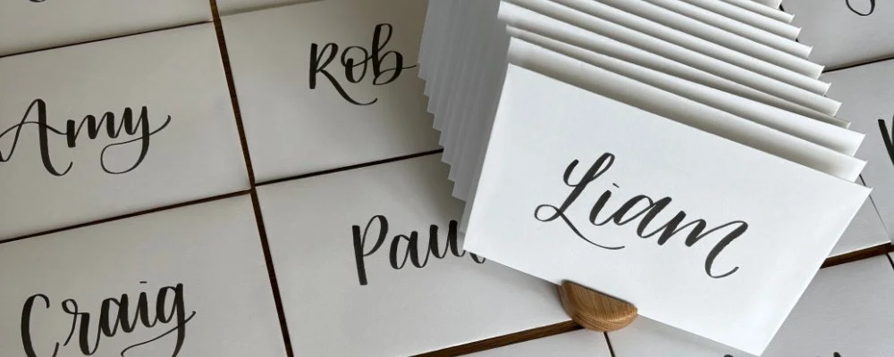 Hand written off white envelopes, with expressive bold black brush pen lettering