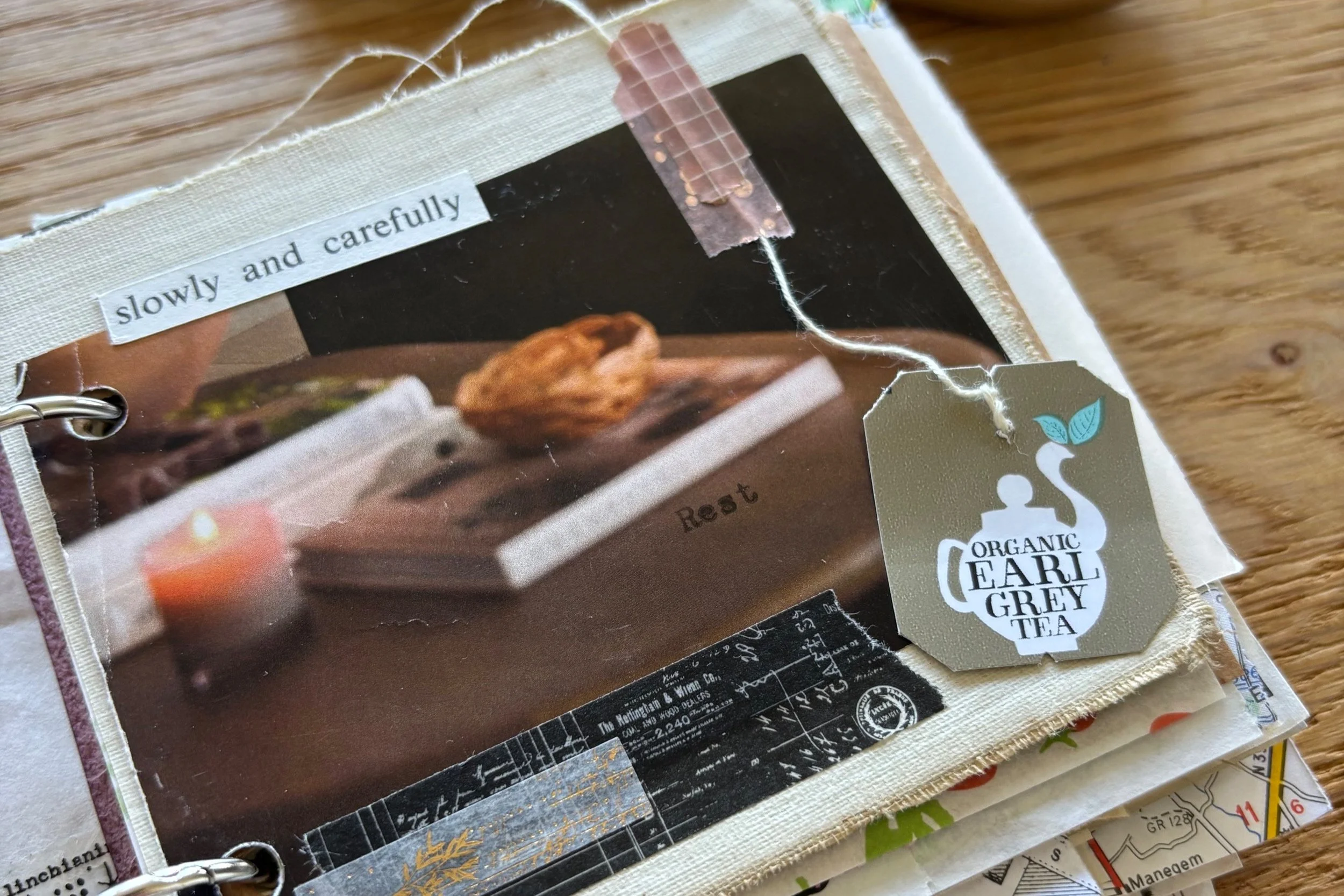 Page of a junk journal. The words "Slowly and carefully" appear at the top, "rest" appears lower down. There is an Earl Grey tea bag tag attached to the page with wash tape on it's string.