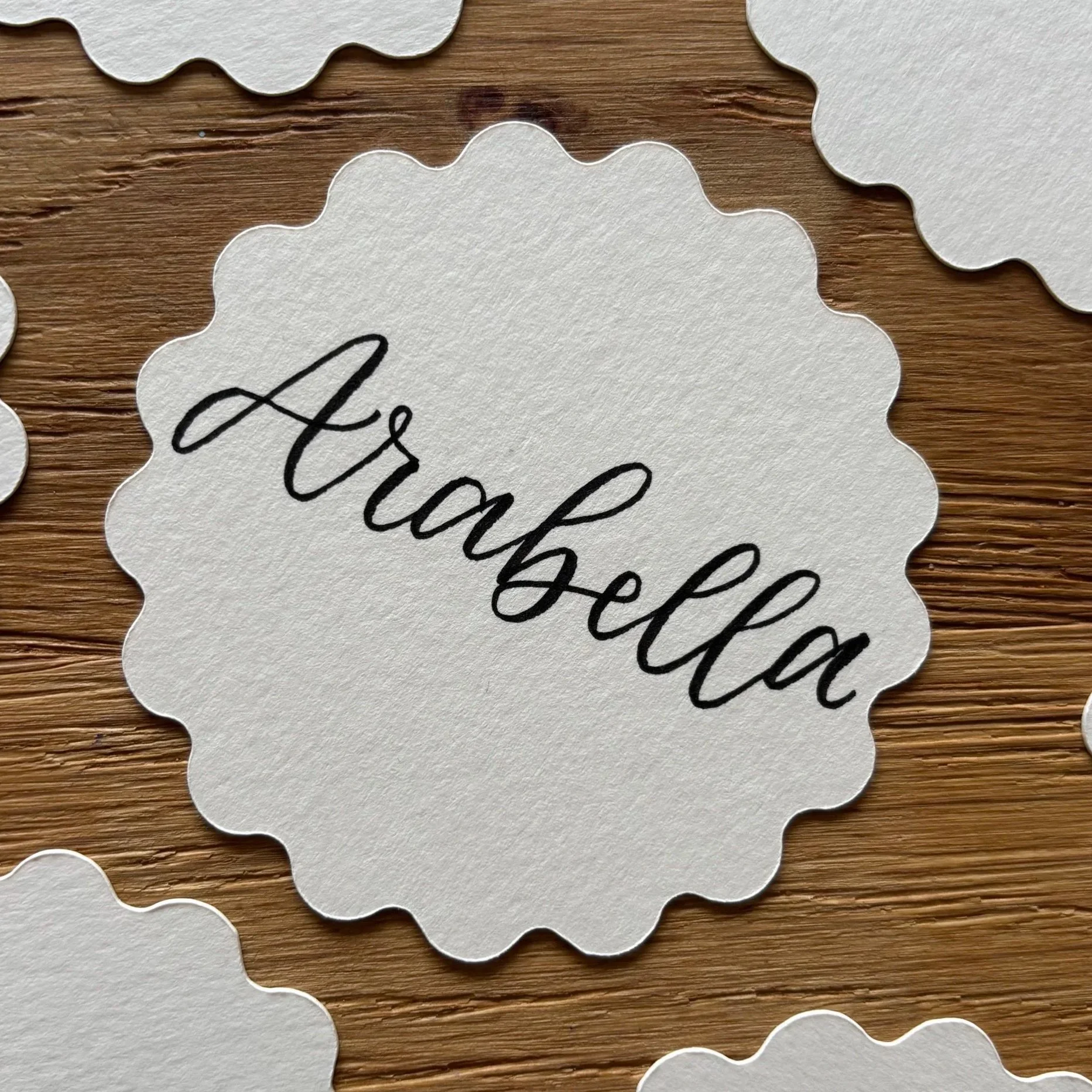 Scalloped circle name place, lettered with "Arabella"