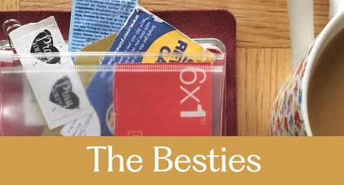 A collection of various ephemera items, including postage stamps and stickers, inside a clear container. The photo has a mustard overlay with the text 'The Besties' written on it.