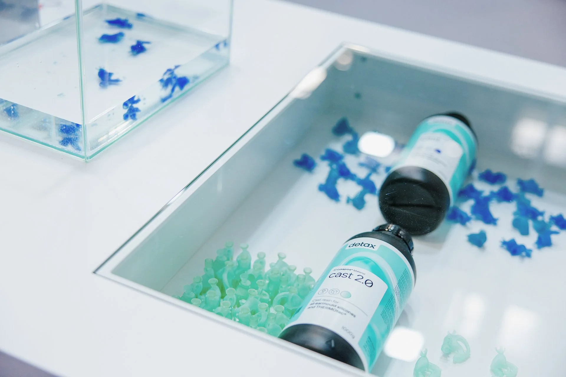 Chemische Reagenzflaschen und blaue und grüne Kunststoffteile in einem Anschaungs-Kasten.