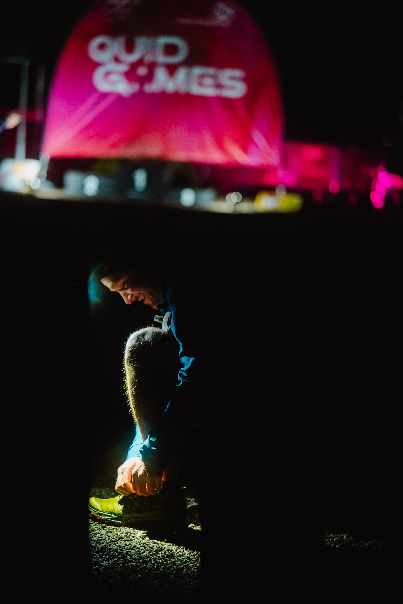 Quid Games_man tying shoelaces beneath Quid Games backdrop.jpg