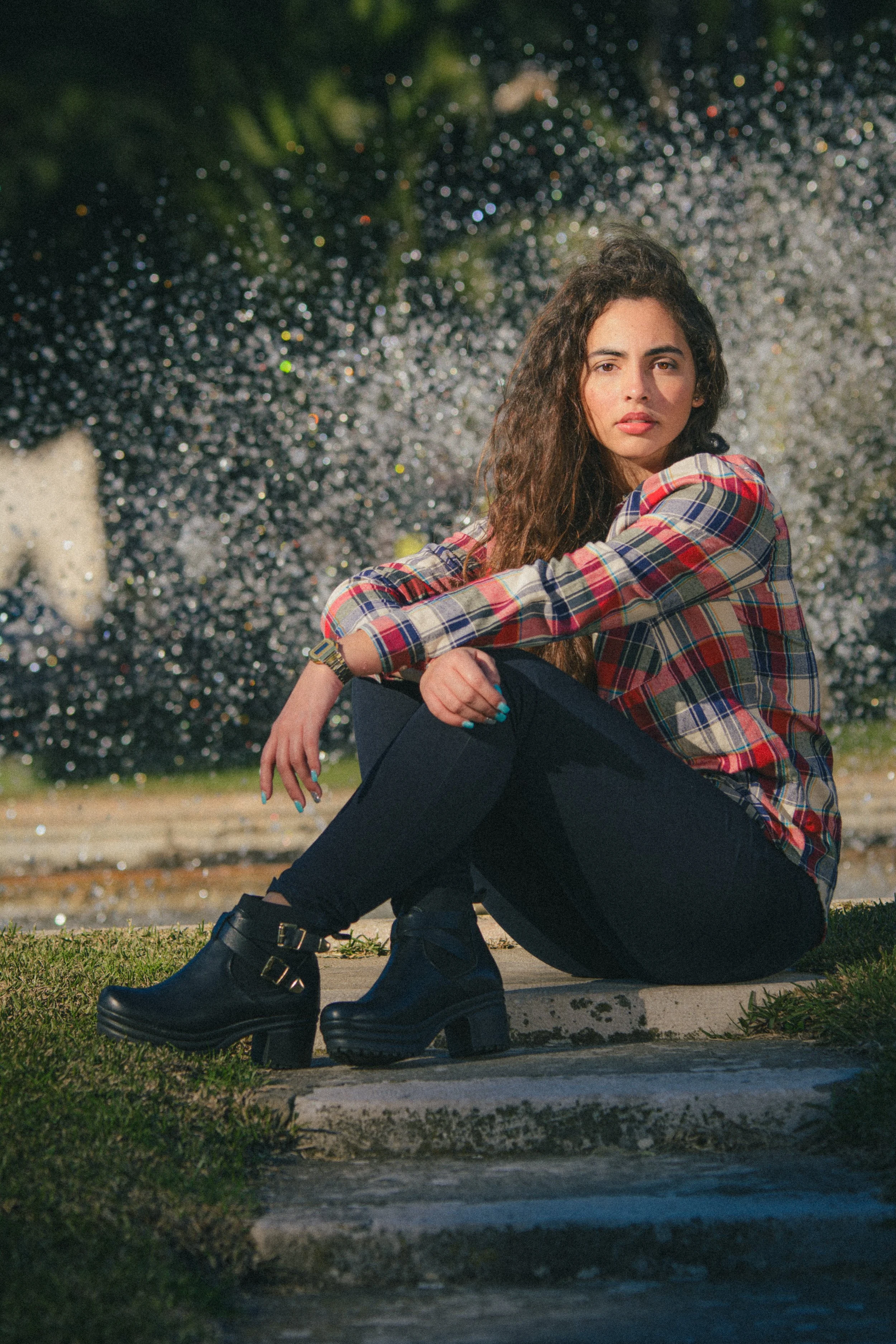 Portrait of Inês Chalupa posing for the camera with water splashing behind her.