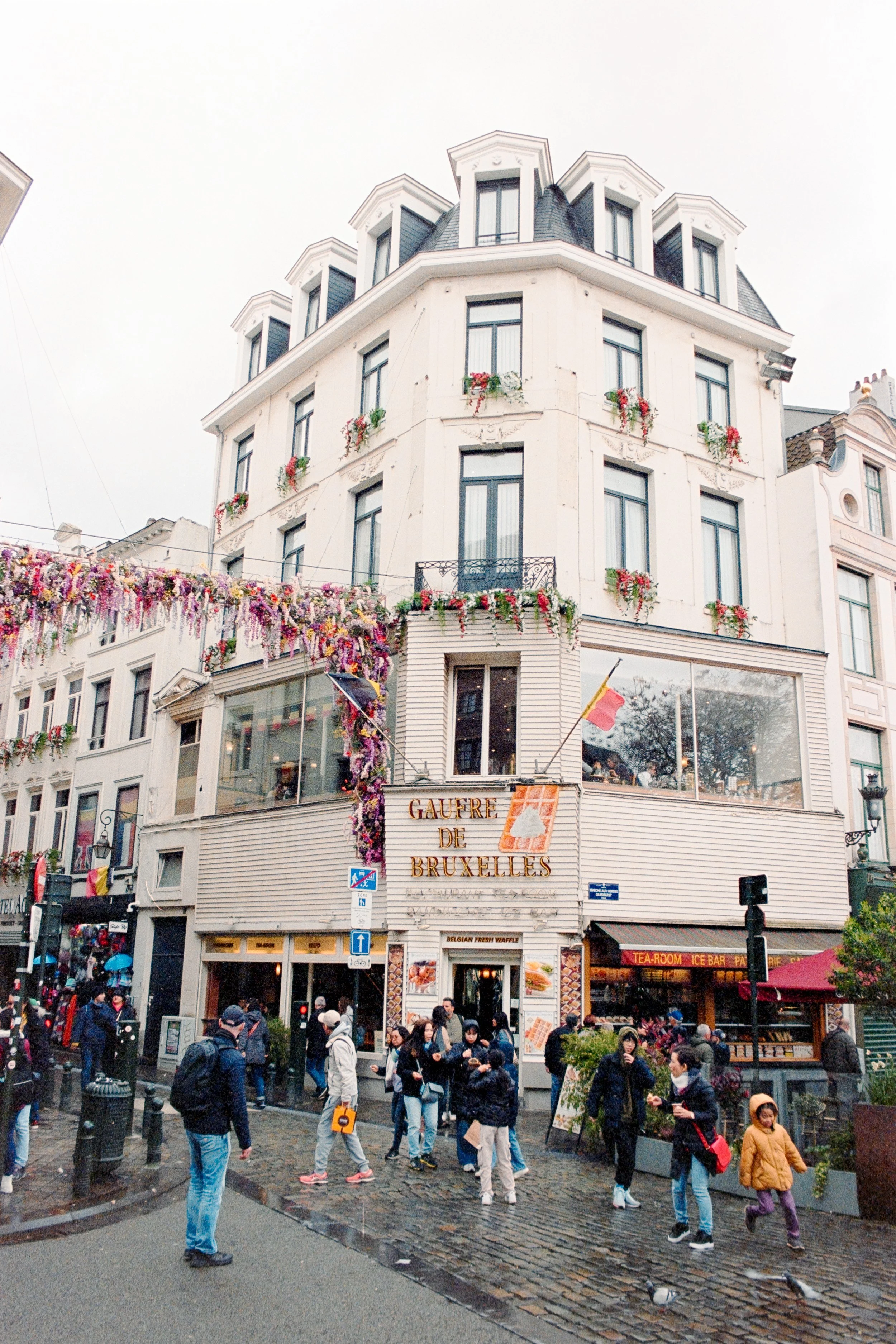 Artistic street photography of Gaufre de Bruxelles in Brussels, Belgium, highlighting ornate floral decor, bustling crowds, and the timeless elegance of European architecture, perfect for fine art prints and exclusive photo collections.