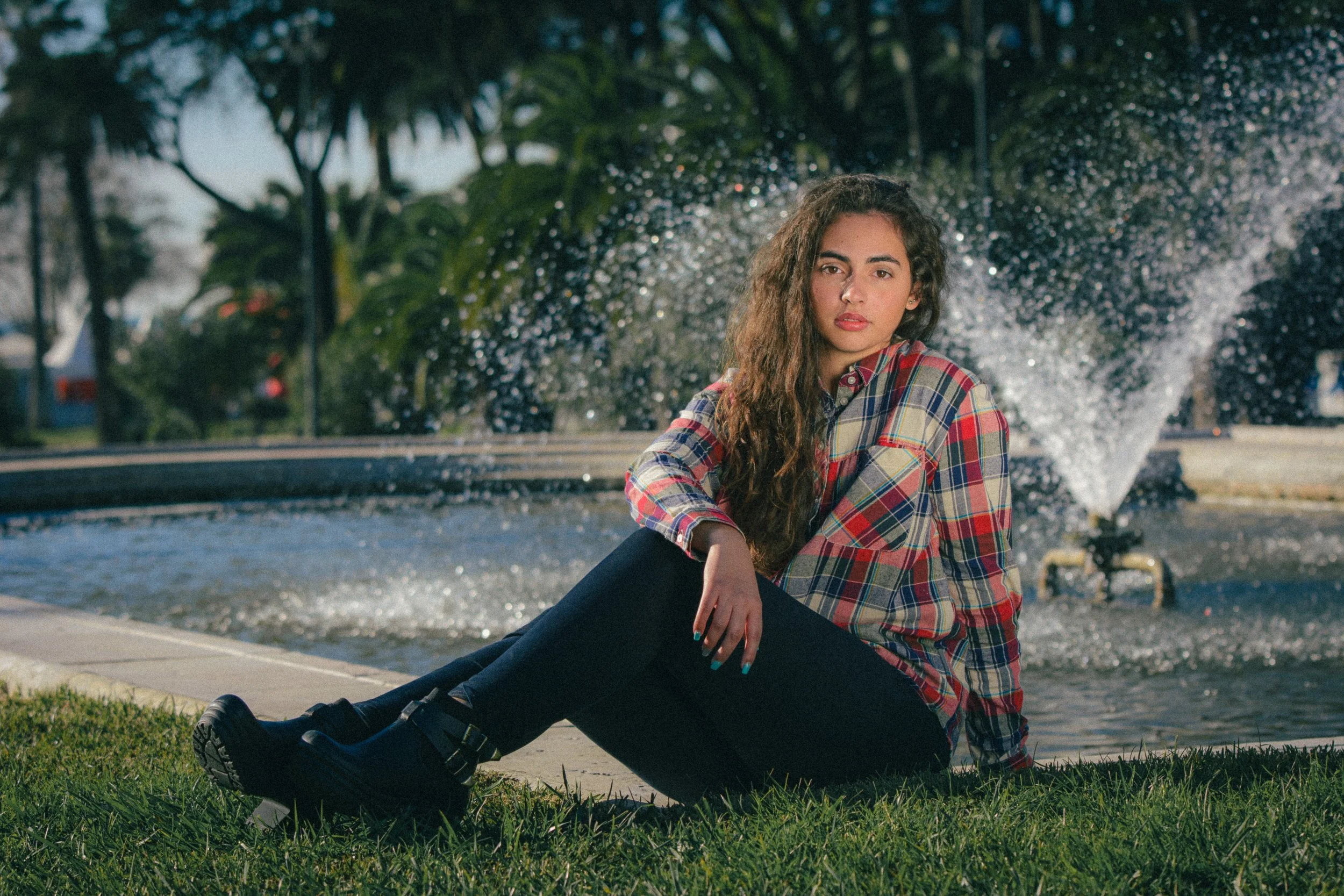 Portrait of Inês Chalupa posing for the camera with water splashing behind her.