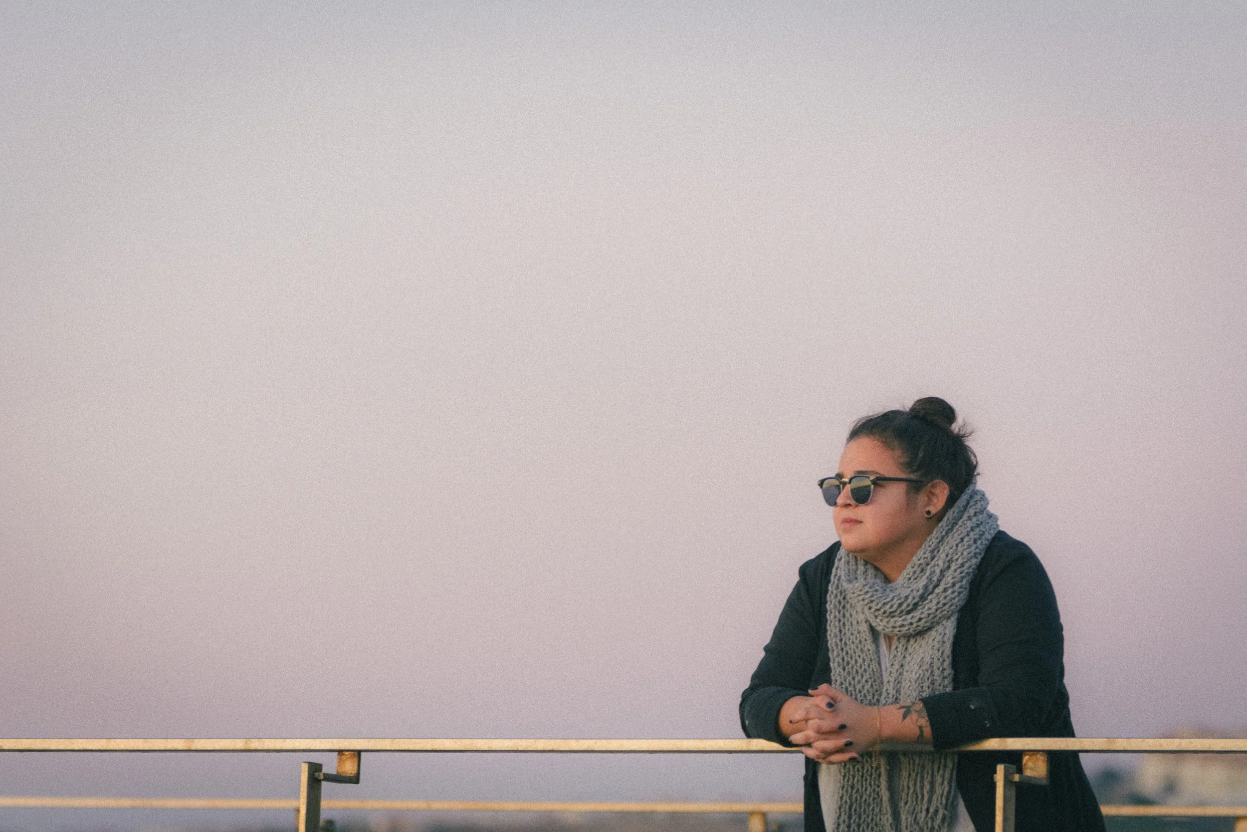 Portrait of Jéssica Cesar Tomé looking at the sunset in a beach in Ericeira Portugal with the purple sky behind her.