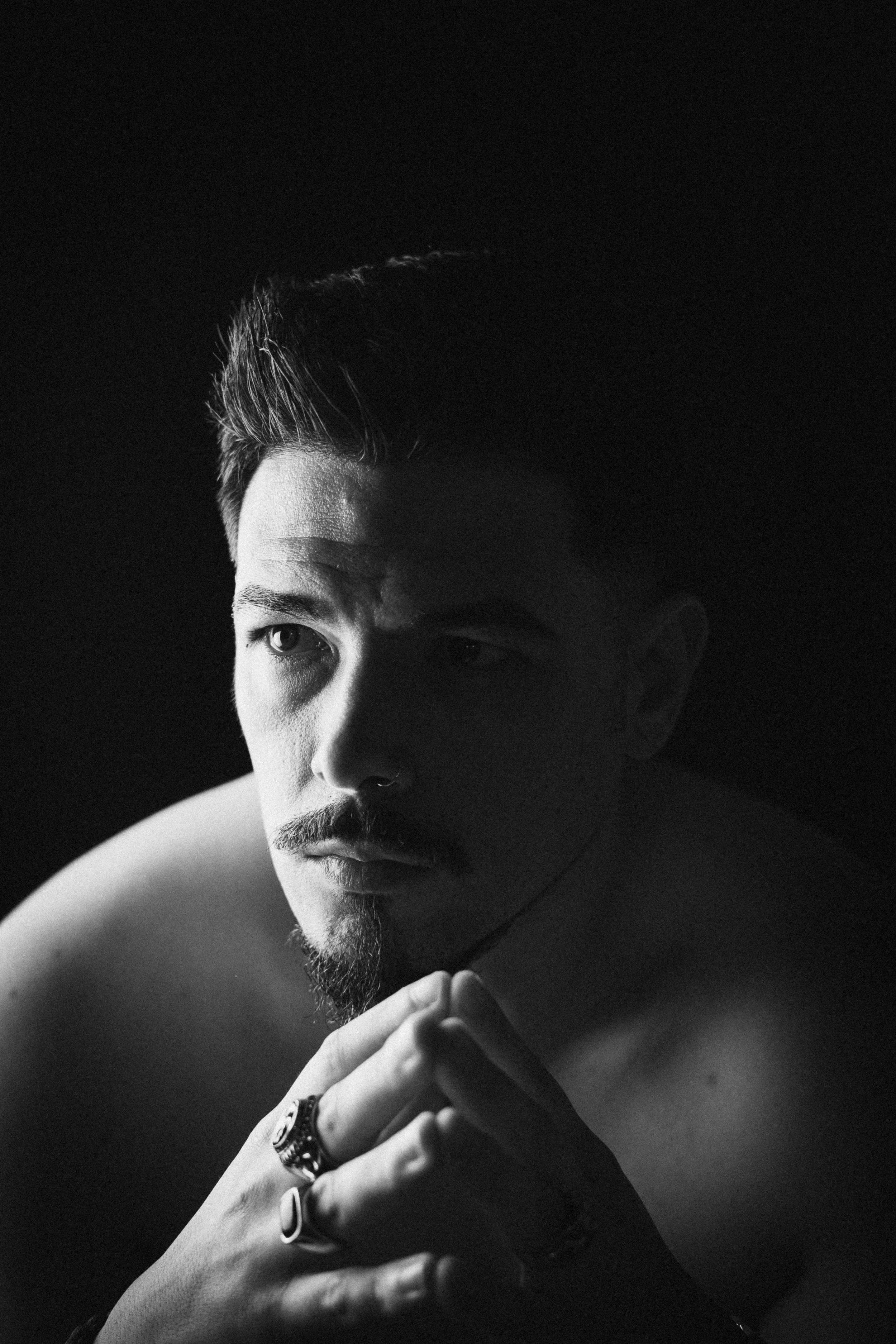 Self-portrait of João Marques in black and white, gazing thoughtfully to the side.