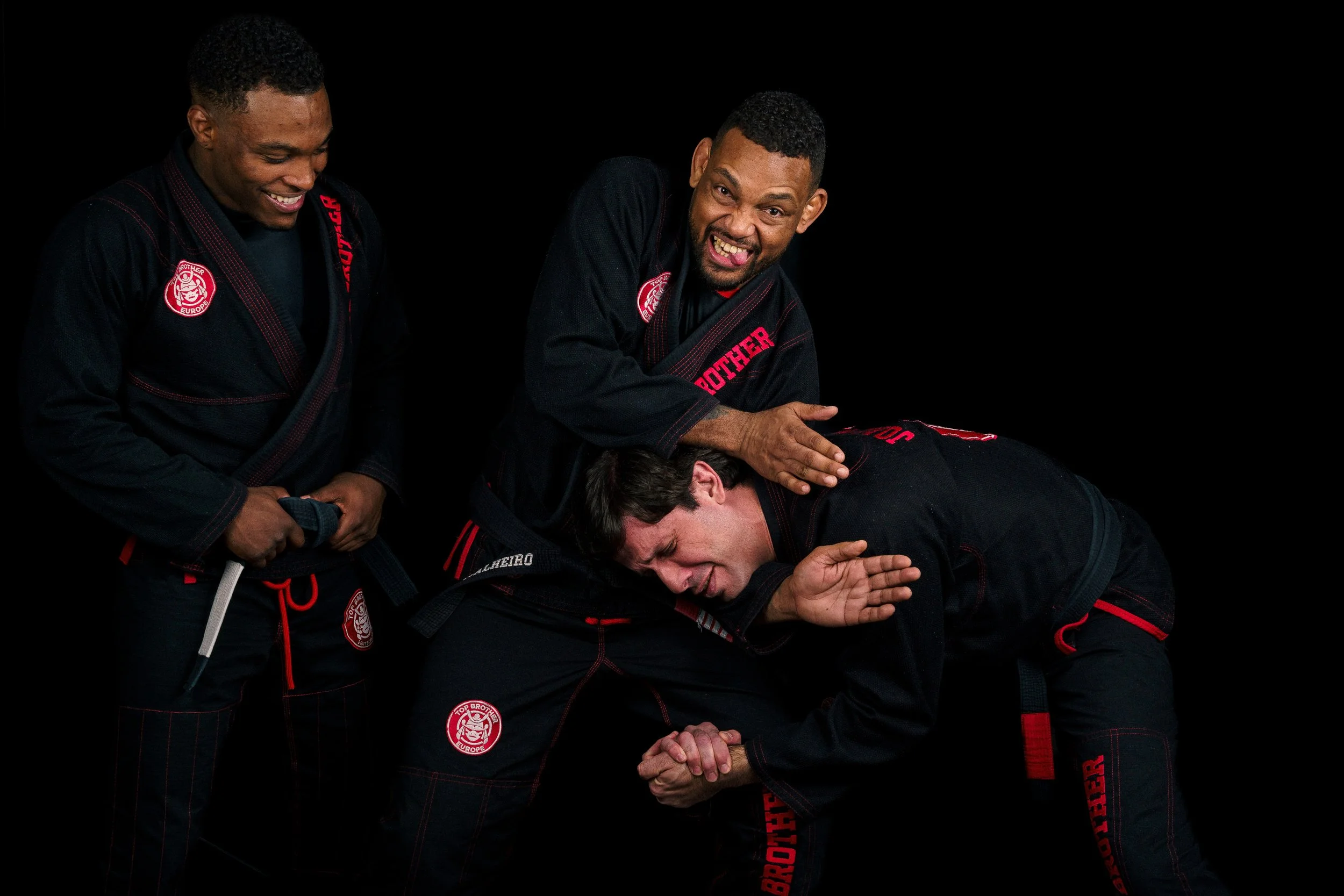 Studio portrait of the tree teachers from Top Brother Düsseldorf, Alex Malheiro, Renan Malheiro e João Macedo, wearing black gis, having fun.