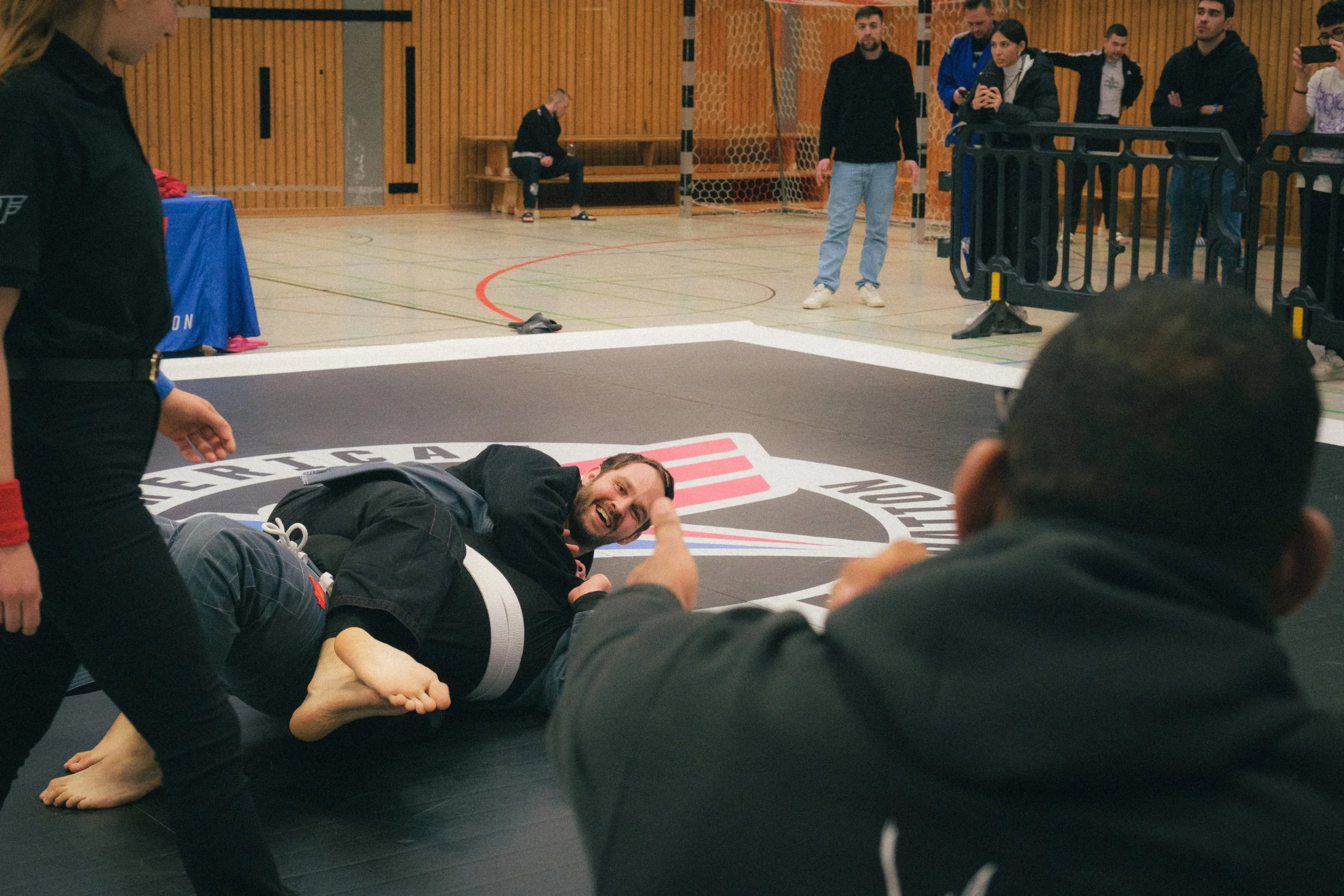 Portrait of BJJ athlete Frederic from Top Brother Düsseldorf smiling at his coach Alex Malheiro during a fight.
