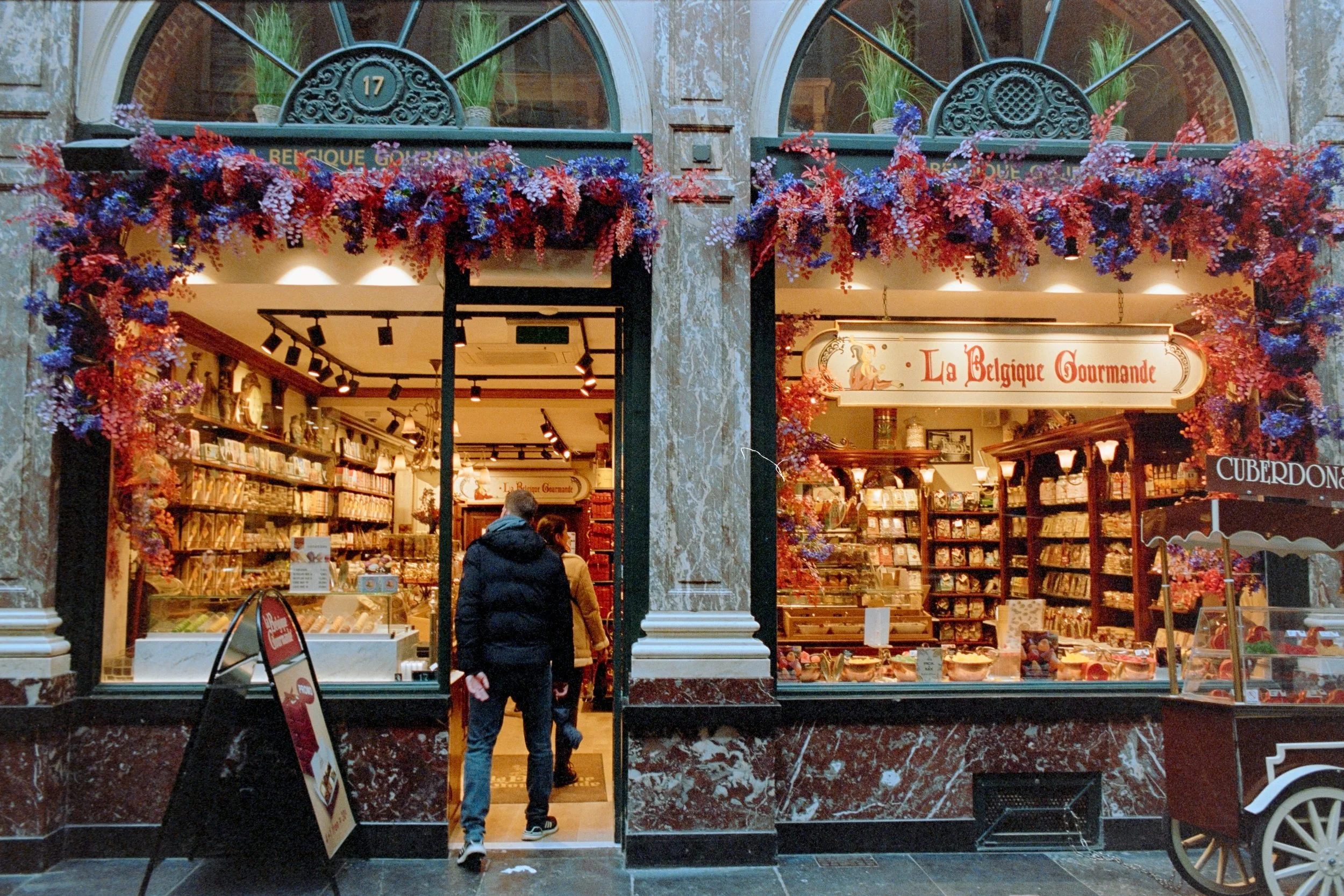 Exclusive fine art travel photography of La Belgique Gourmande shop inside Galeries Royales Saint-Hubert, Brussels. Captures the vibrant colors and intricate architectural details of this premium Belgian chocolate and confectionery store. Ideal for l