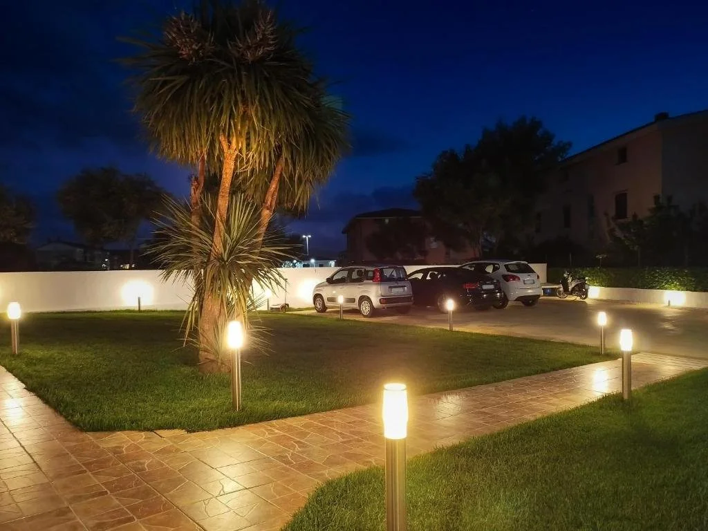 giardino illuminato di notte con ampio parcheggio