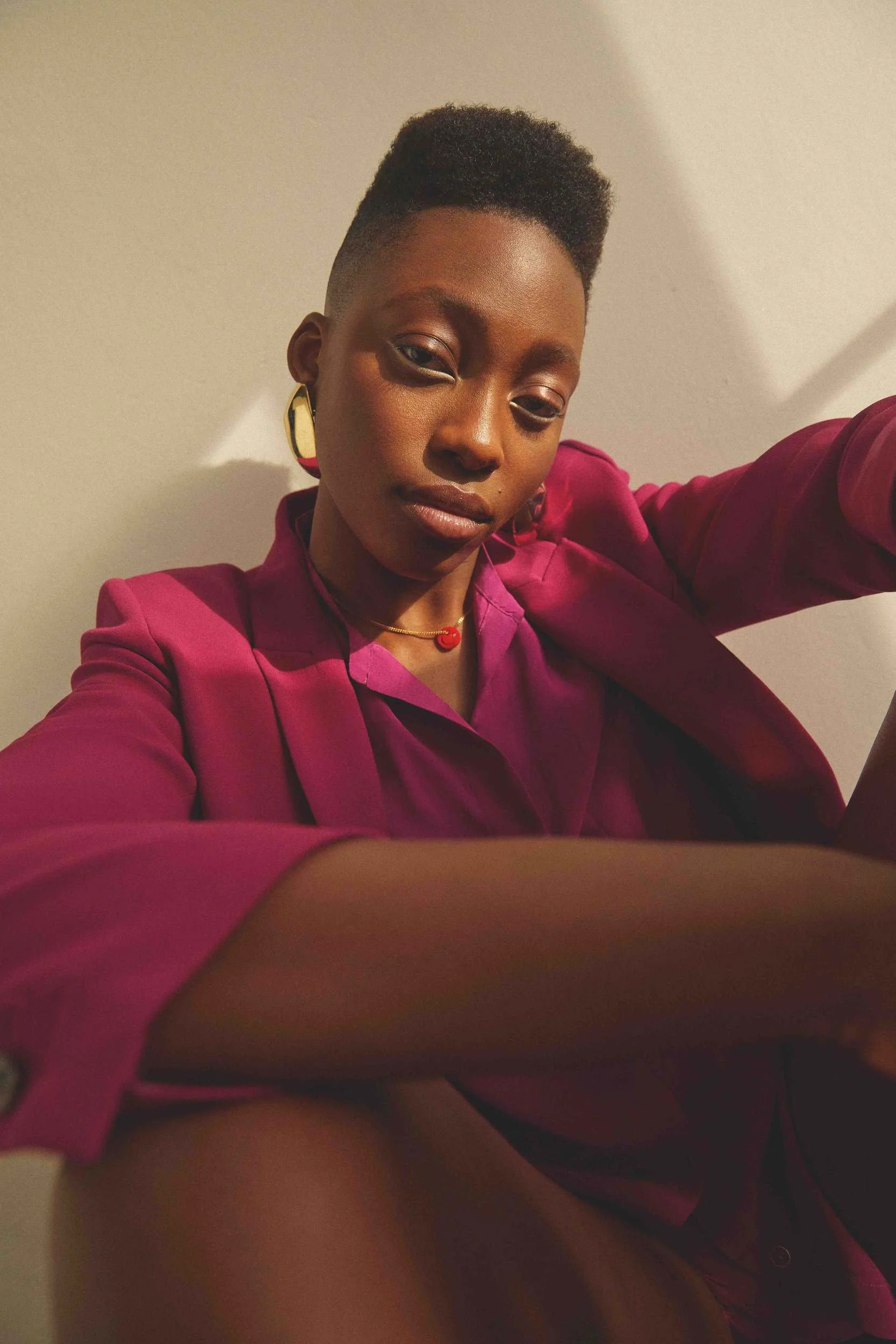 Pink blouse, seated with arms crossed