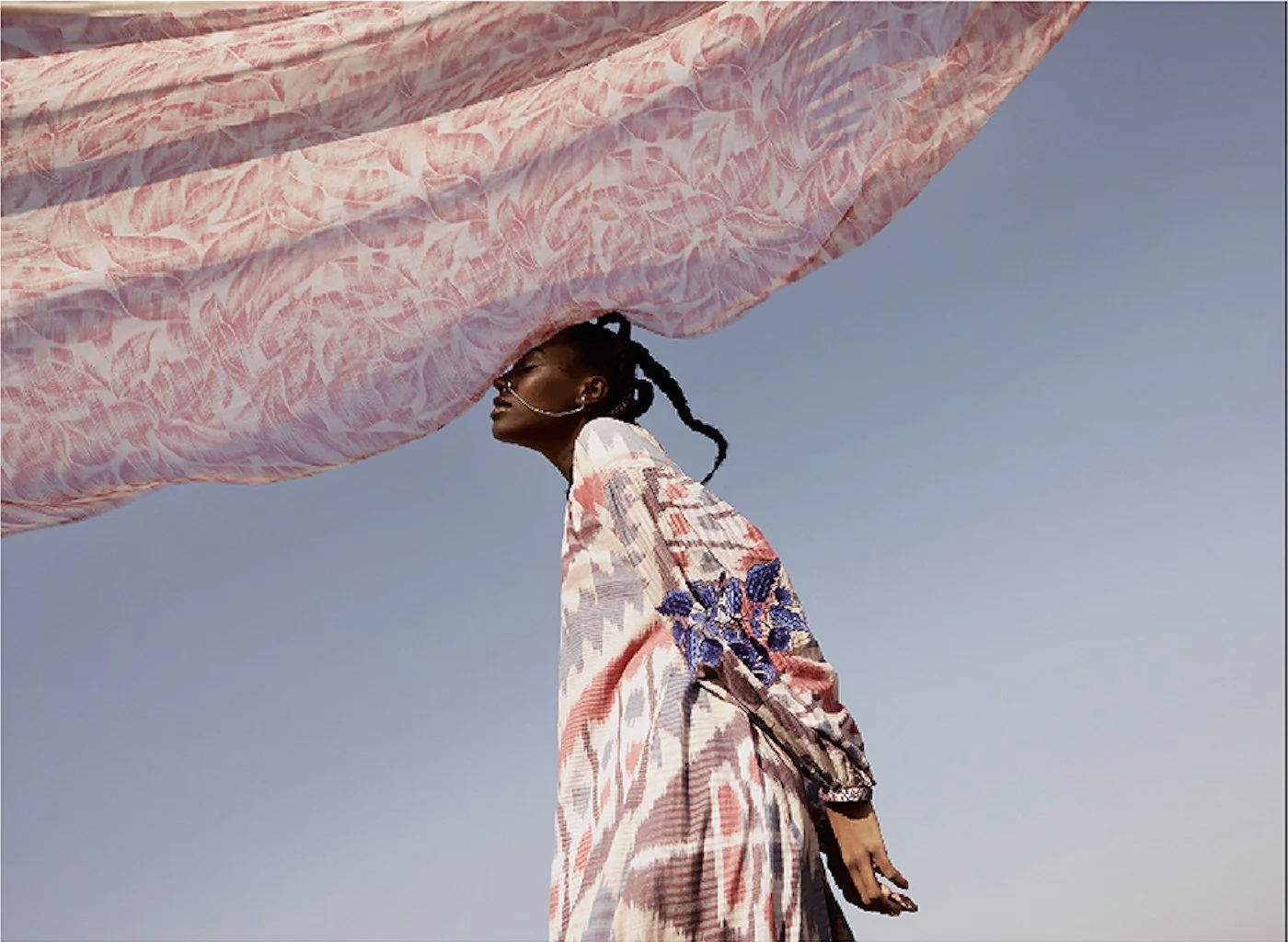 Pink scarf flying in the wind against the sky